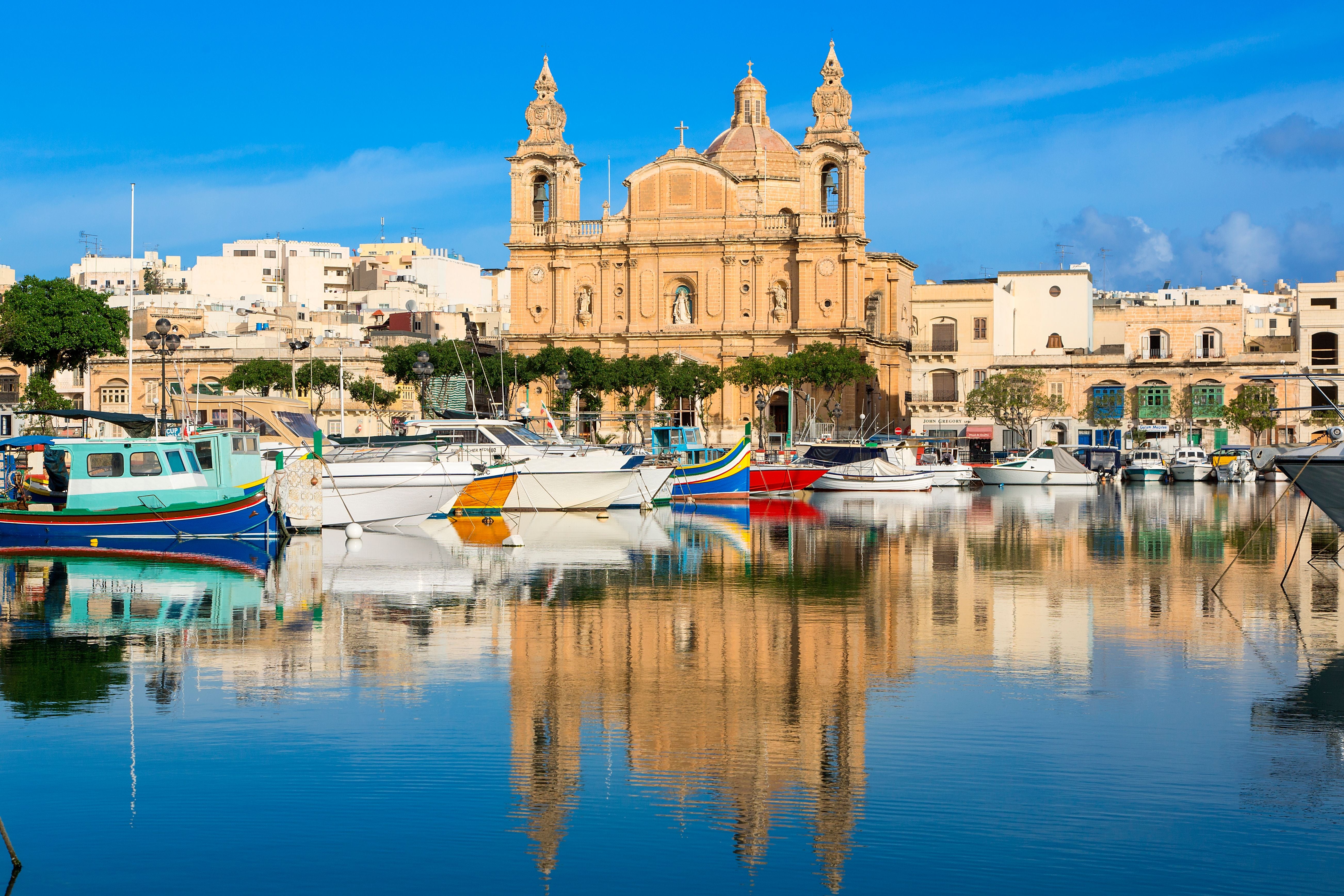 Boote im Hafen vor der barocken St.-Josef-Kirche in Msida bei Valletta, Malta, spiegeln sich im Wasser.