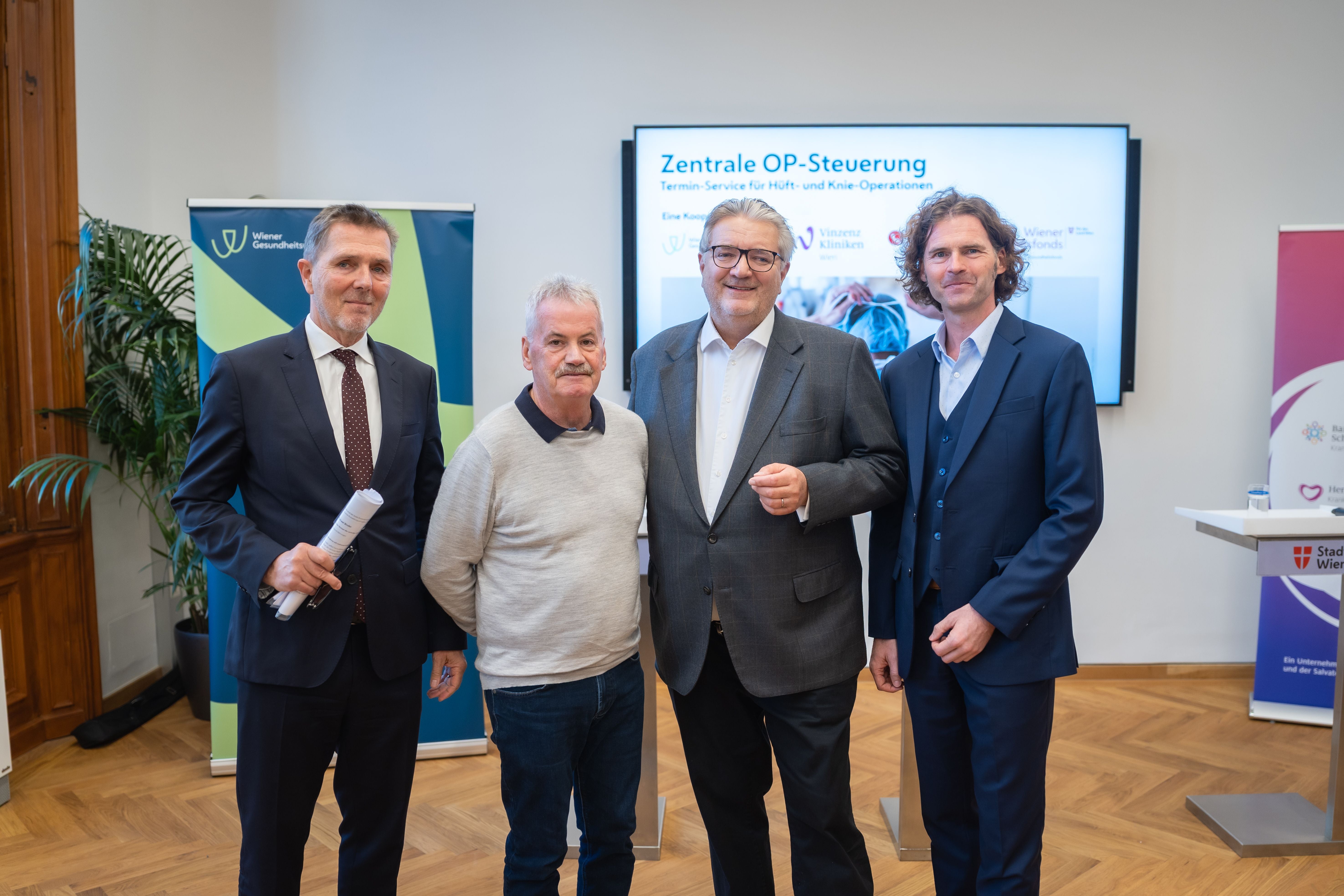 Vier Männer stehen vor einem Bildschirm mit der Aufschrift „Zentrale OP-Steuerung“.