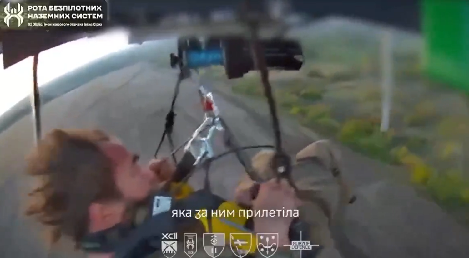 Ein Mann fliegt mit einem Motor-Gleitschirm über eine Landschaft in der Ukraine.