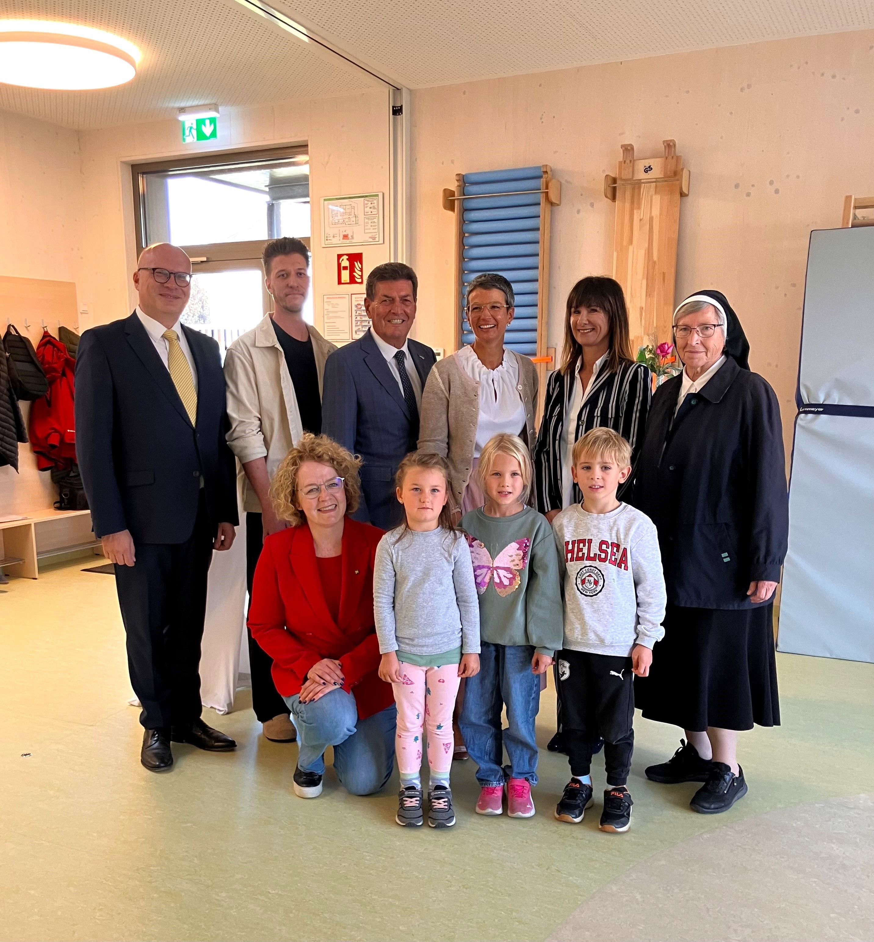 Bezirkshauptmann Günther Stöger, Kindergartenleiter Clemens Angerer, Bürgermeister Harald Leopold, Stadträtin Birgit Meinhard, Kindergarteninspektorin Elisabeth Heiß und Schwester Elvira Reuberger, vorne (v.l.n.r.): Familien-Landesrätin Christiane Teschl-Hofmeister, Sophie, Pia und Franz