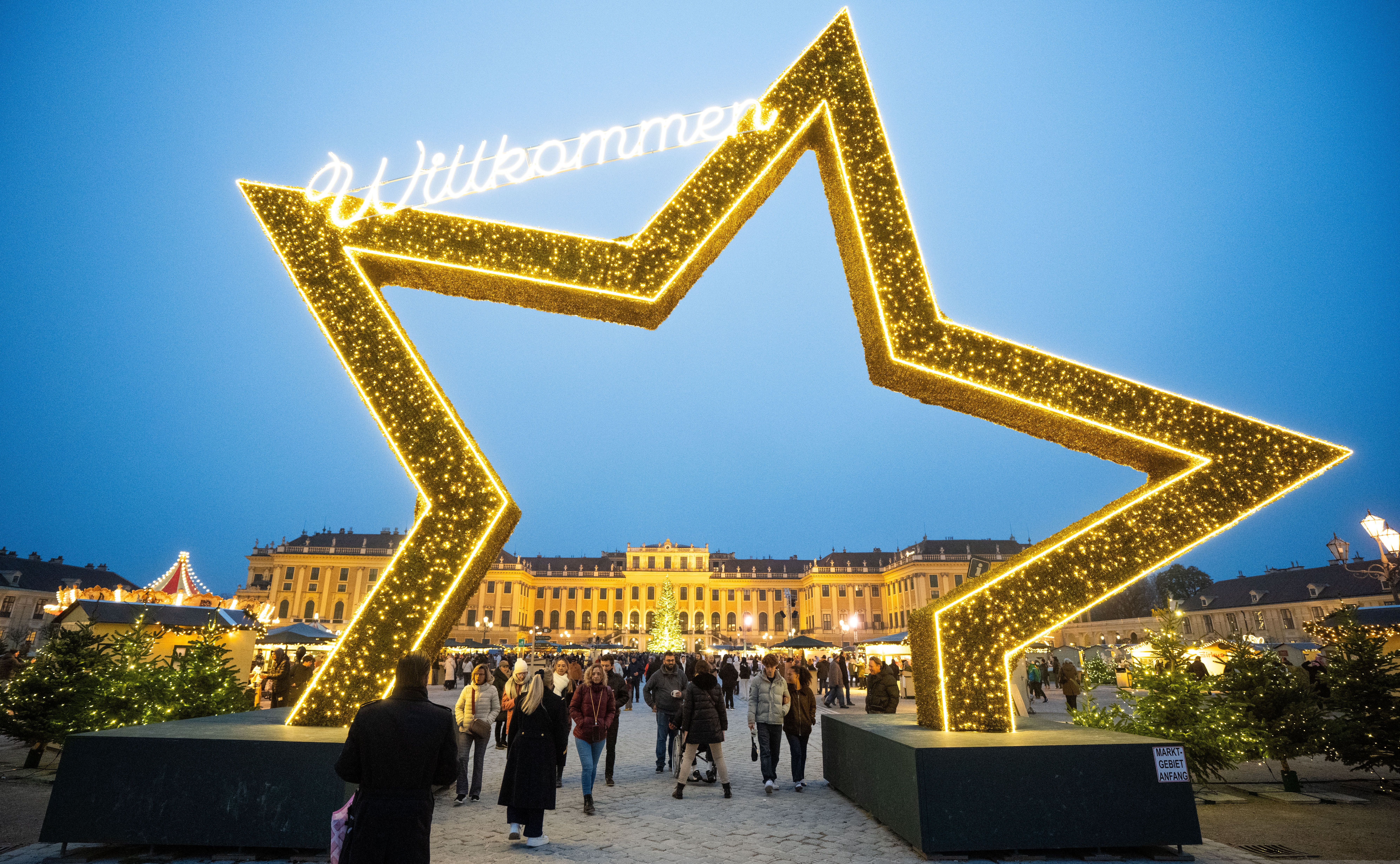 Beleuchteter Stern mit "Willkommen" am Eingang zum Weihnachtsmarkt vor Schloss Schönbrunn in Wien.
