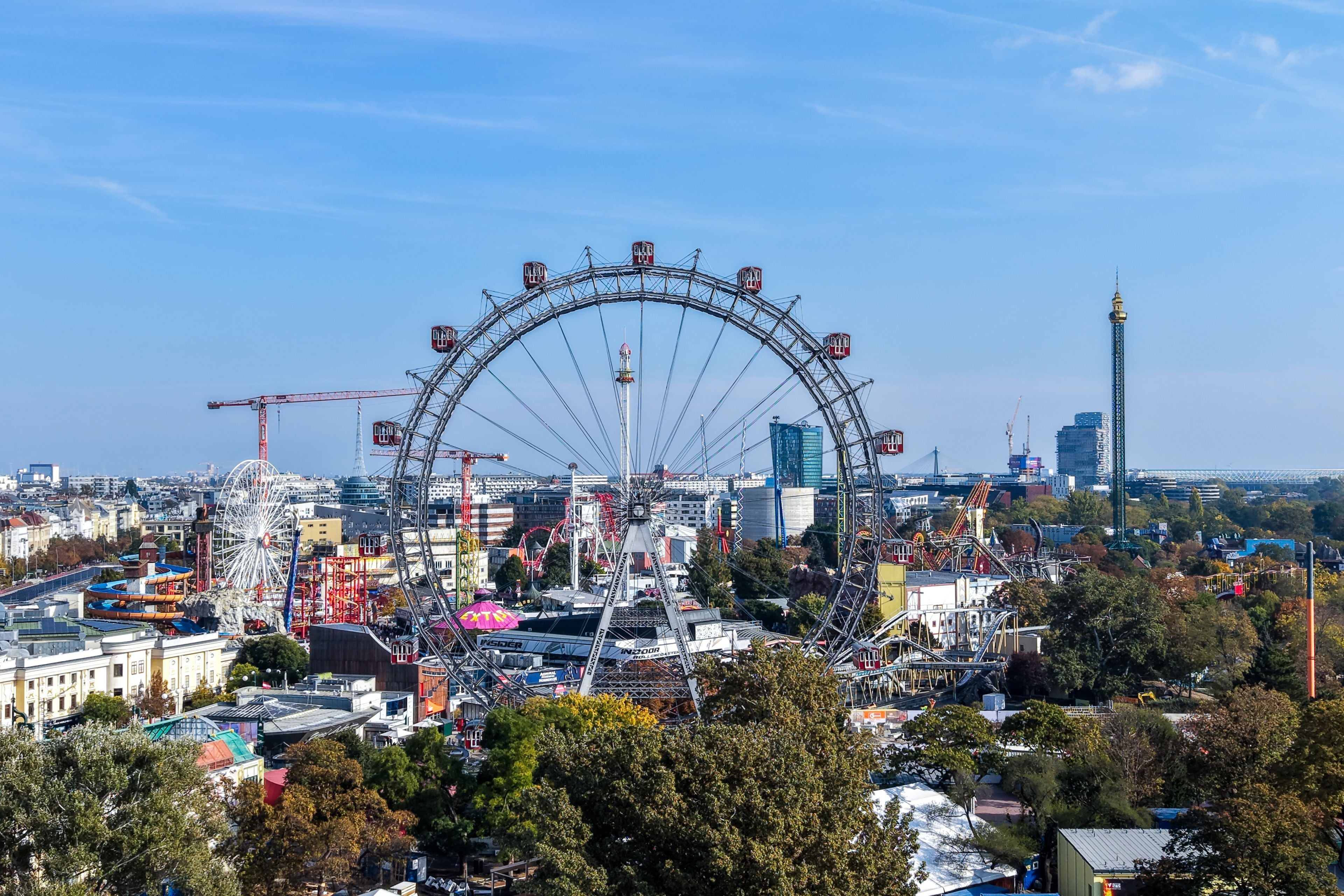 Luftaufnahme vom Wiener Wurstelprater mit dem Riesenrad an einem sonnigen Tag.
