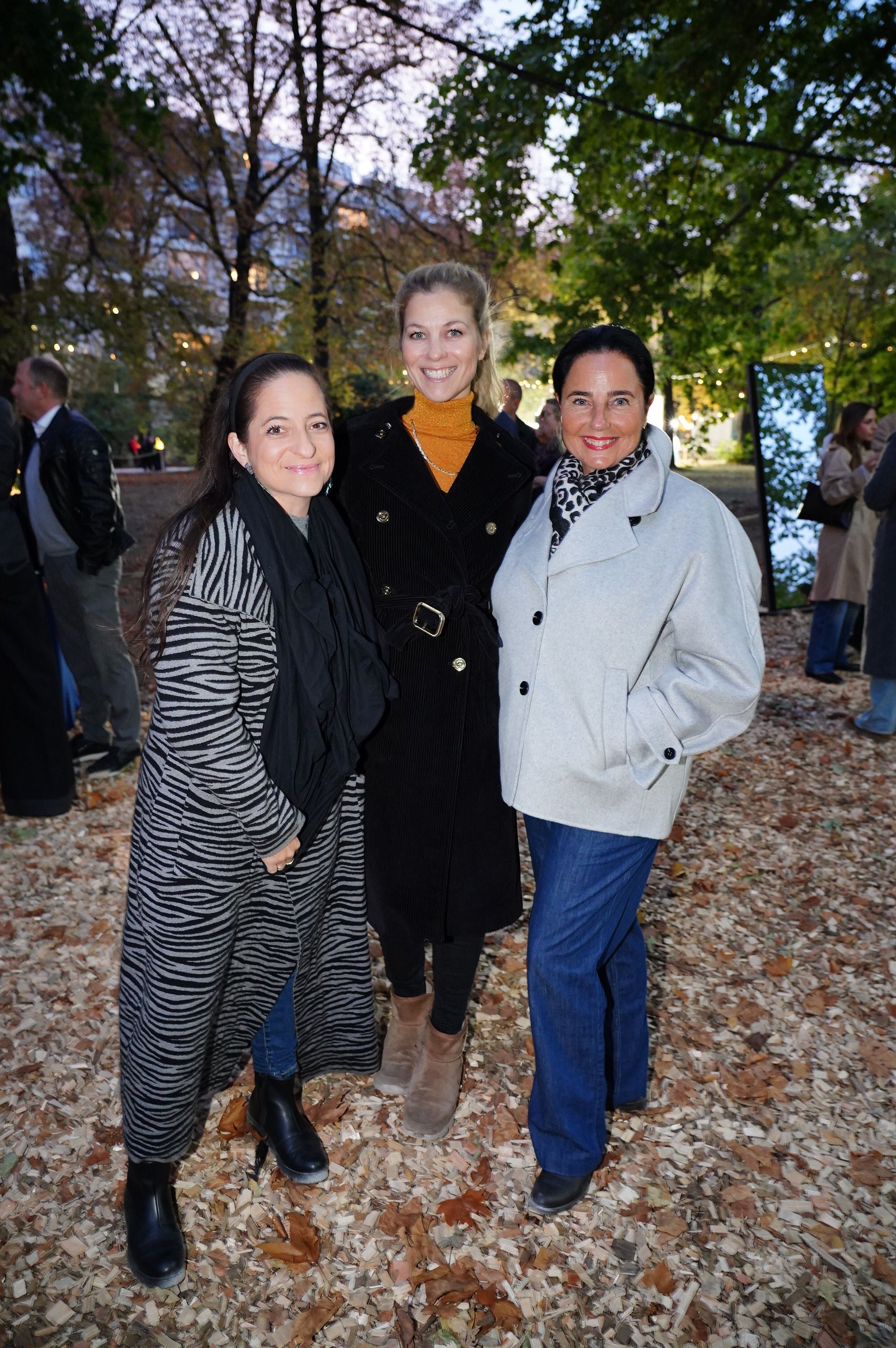 Drei Frauen posieren lächelnd im herbstlichen Park bei der Veranstaltung Klanglicht.