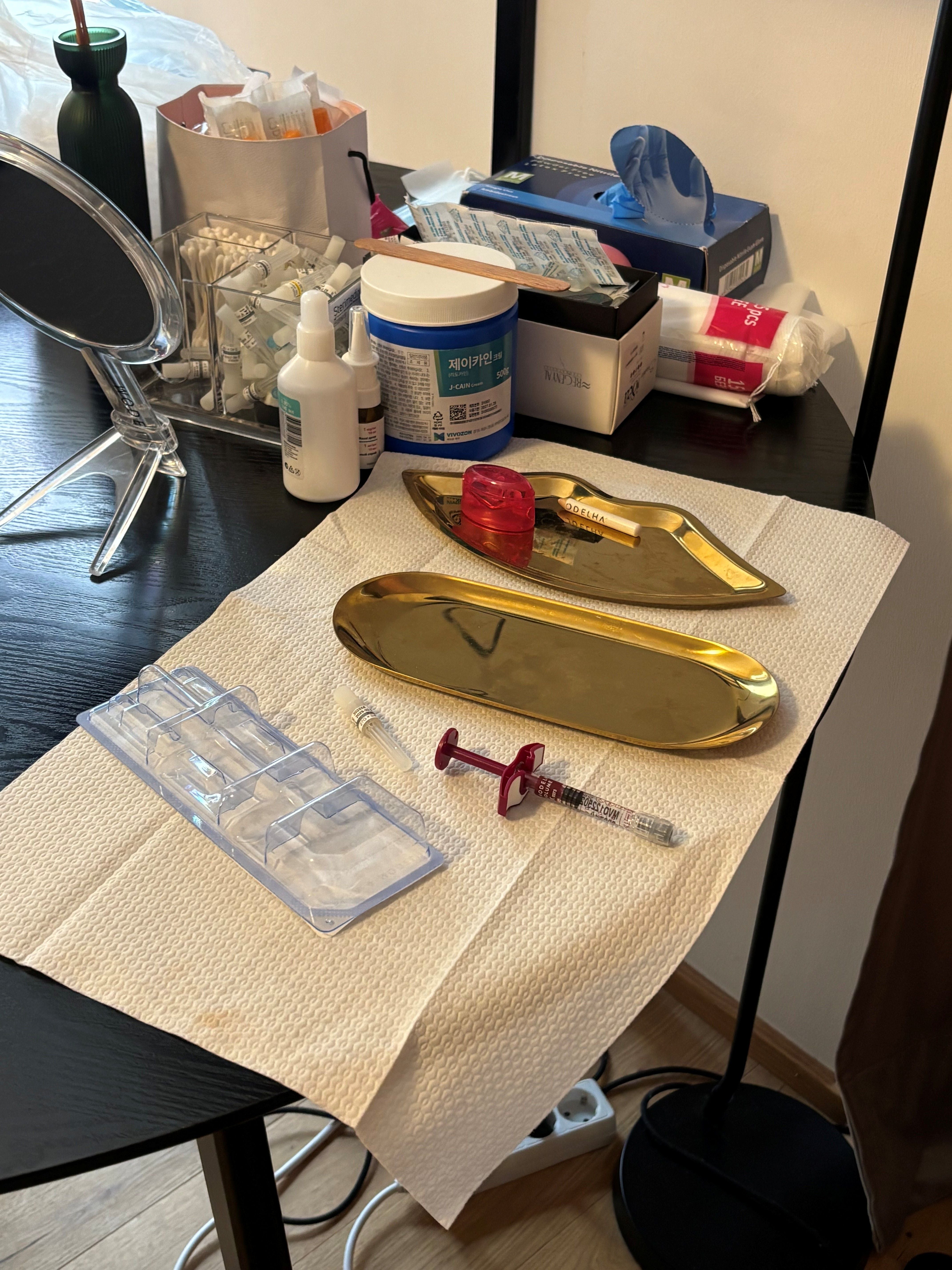 Tisch mit medizinischen Utensilien, Kanülen, Spritzen und Desinfektionsmitteln in einer Klinik.