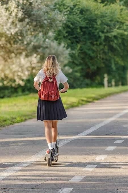 Mädchen mit rotem Rucksack fährt auf einem E-Scooter einen Radweg entlang.