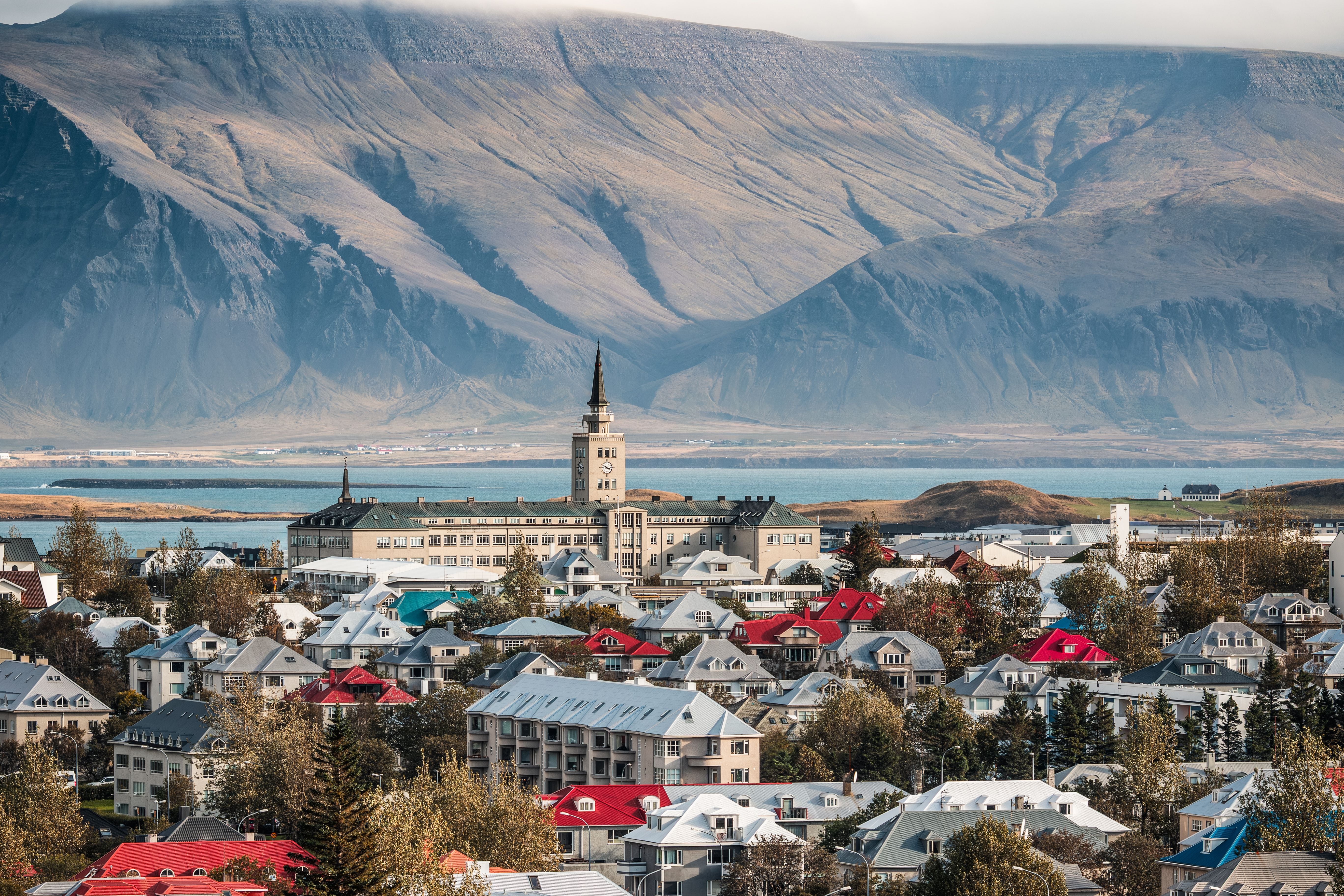 Stadtansicht von Reykjavik mit bunten Häusern, Tækniskólinn und Berg Esjan im Hintergrund.