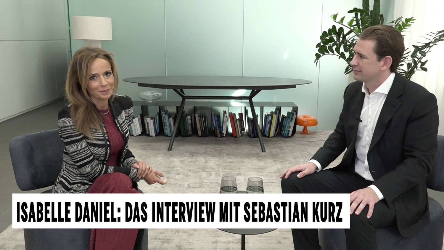 Zwei Personen sitzen sich in einem modernen Büro gegenüber und führen ein Interview.