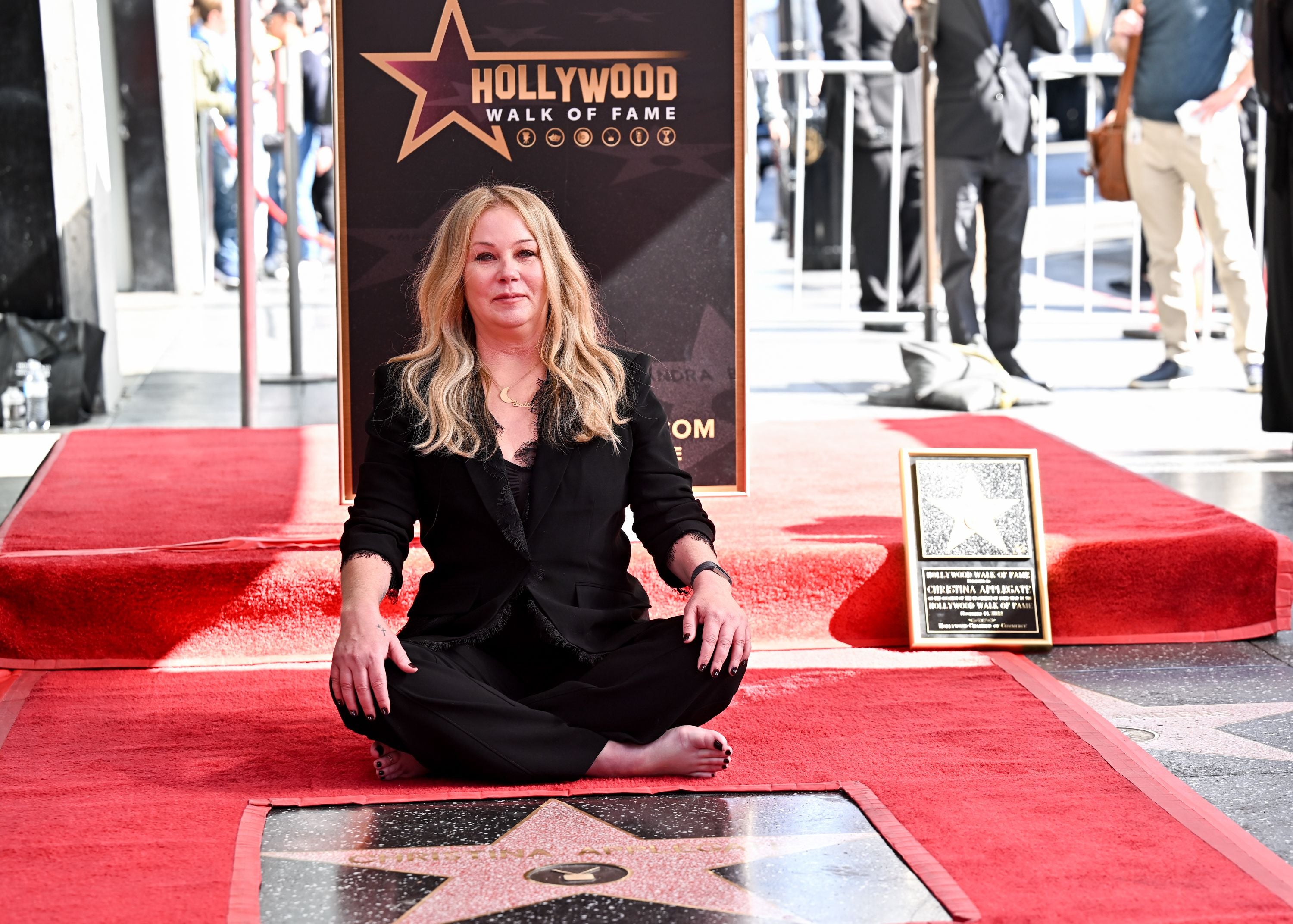 Christina Applegate sitzt barfuß bei ihrer Sternverleihung auf dem Hollywood Walk of Fame.