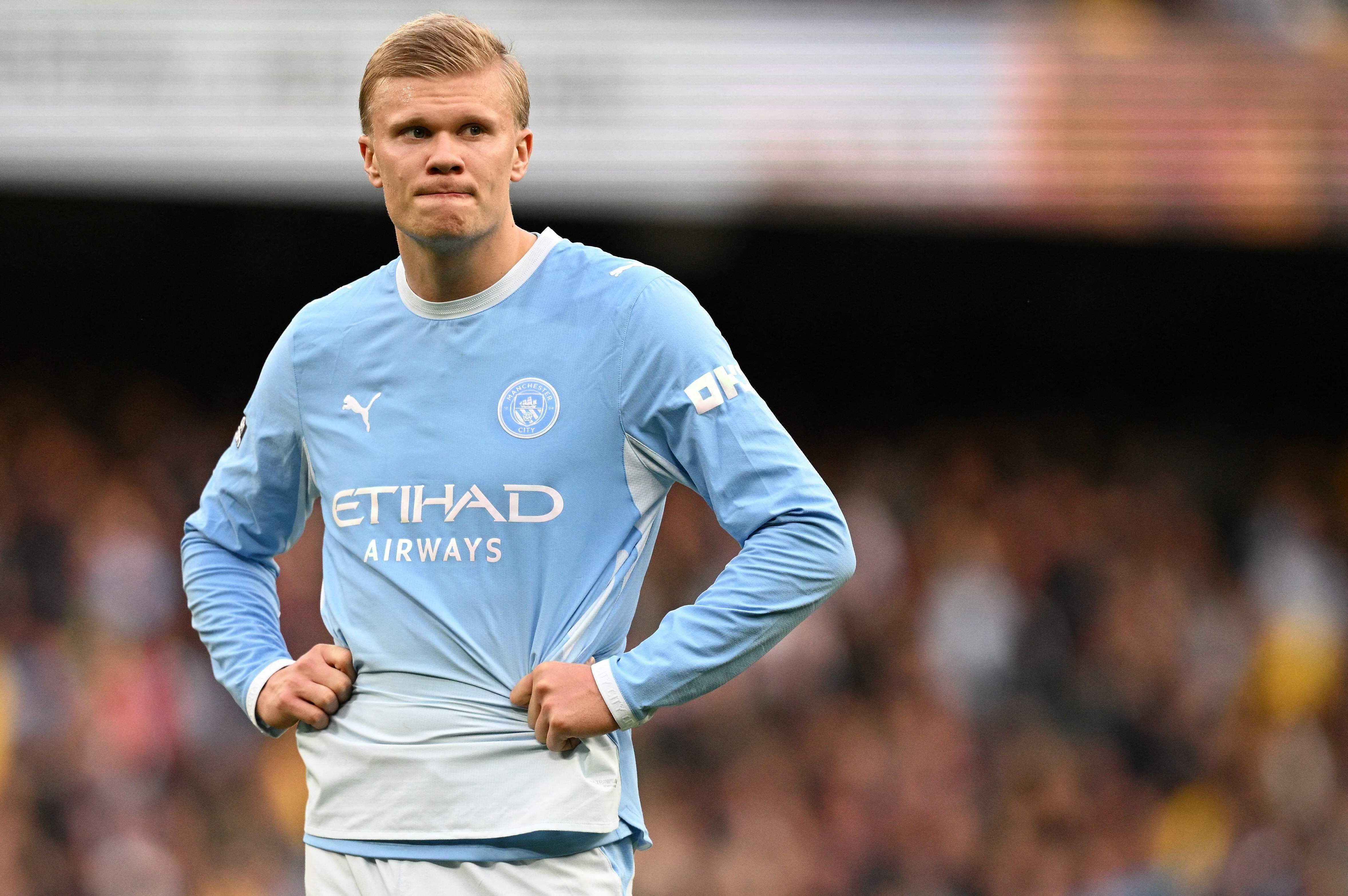 Ein Fußballspieler von Manchester City steht enttäuscht auf dem Spielfeld mit den Händen in der Hüfte.