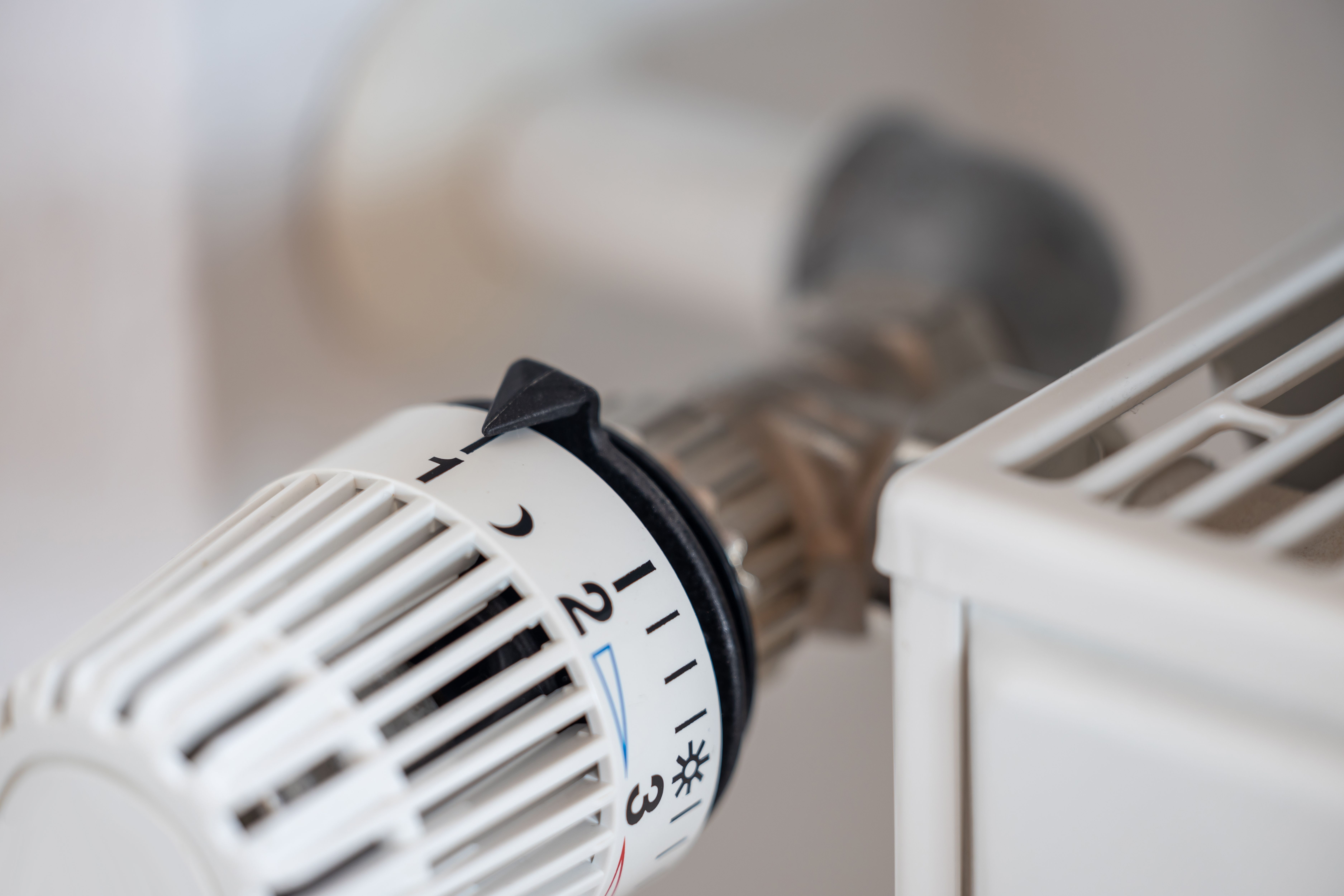 Nahaufnahme eines Heizkörperthermostats mit Temperatureinstellungen.
