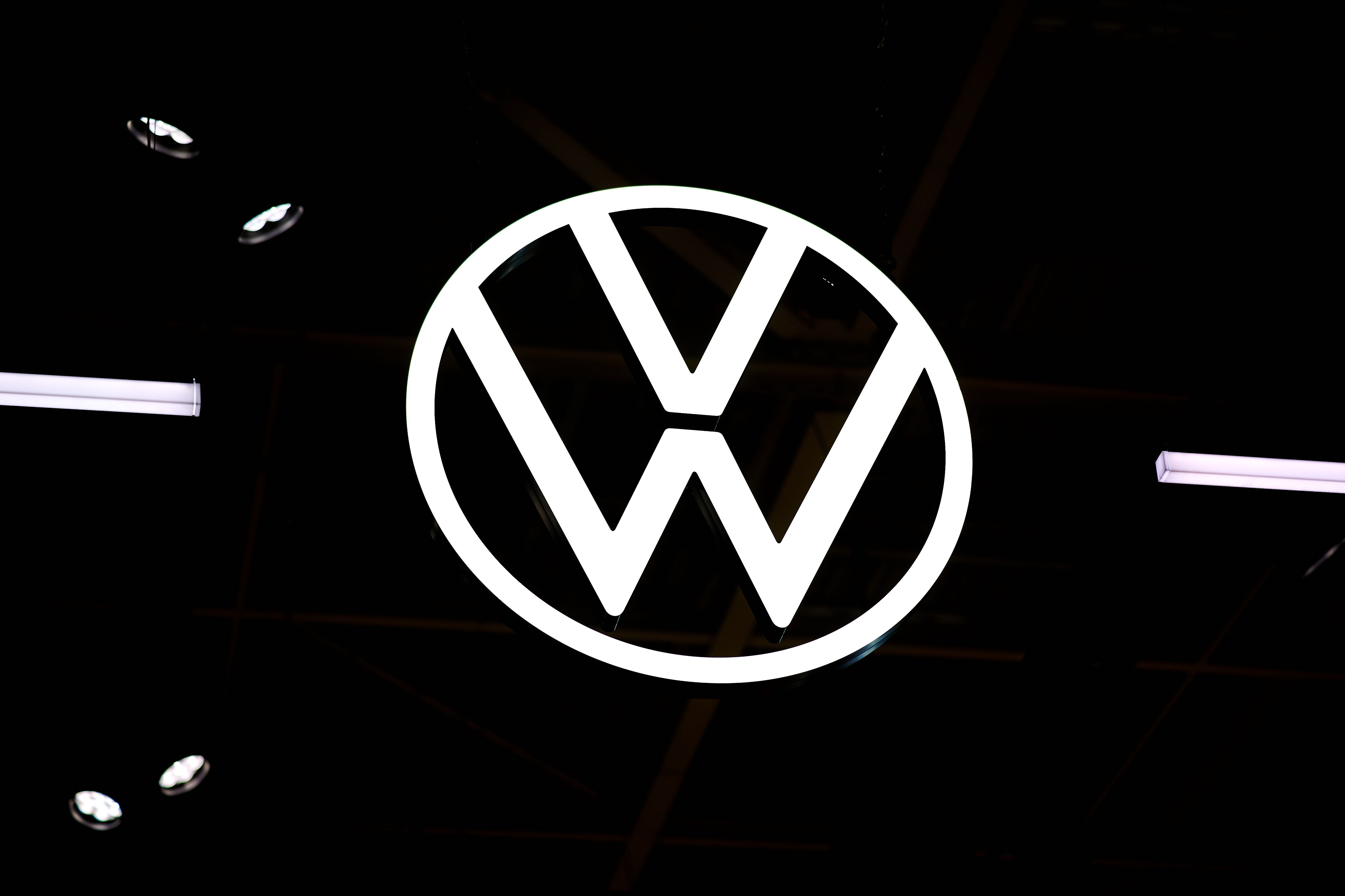 Leuchtendes Volkswagen-Logo vor dunklem Hintergrund.