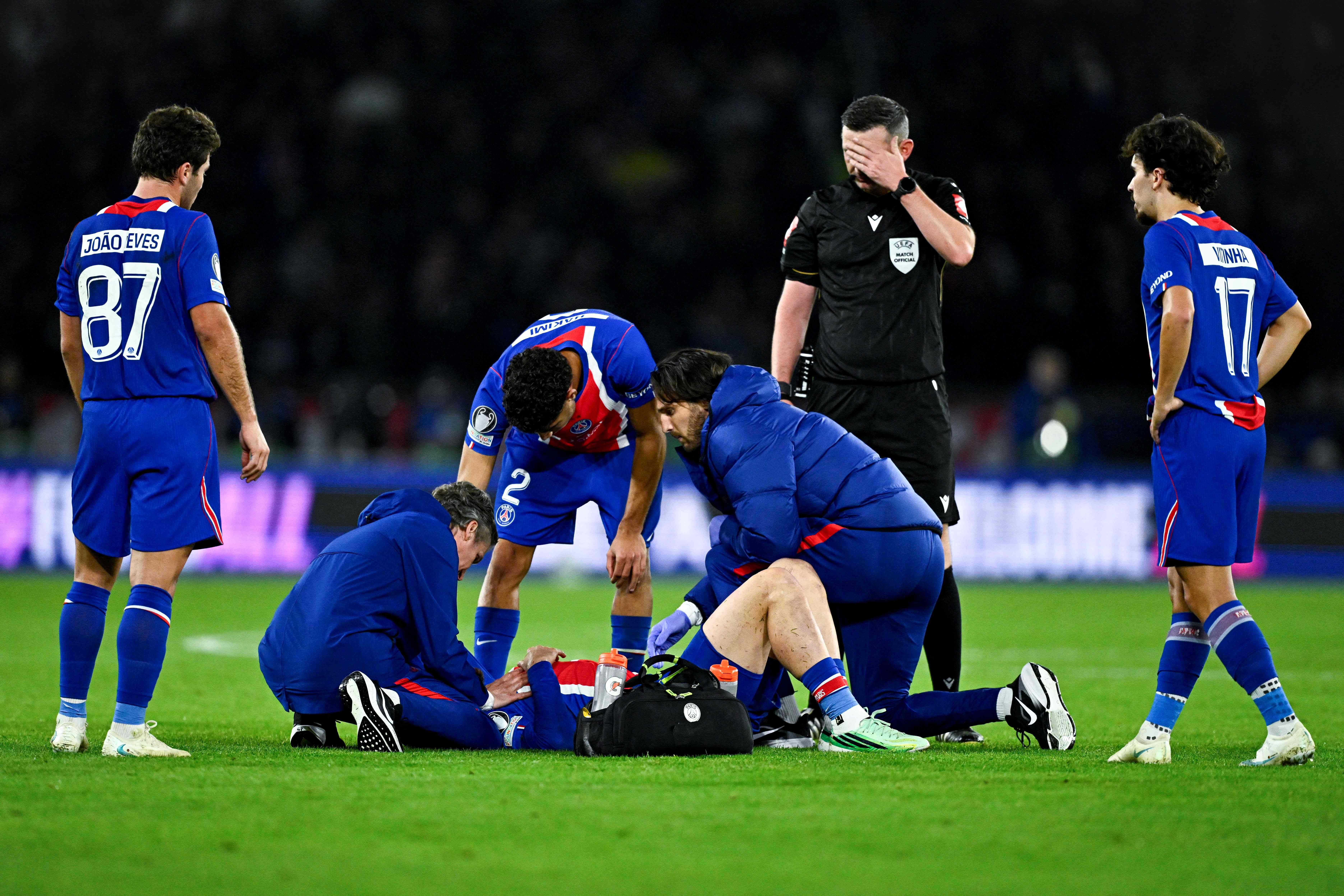 Sanitäter versorgen einen verletzten Fußballspieler während eines Champions-League-Spiels.