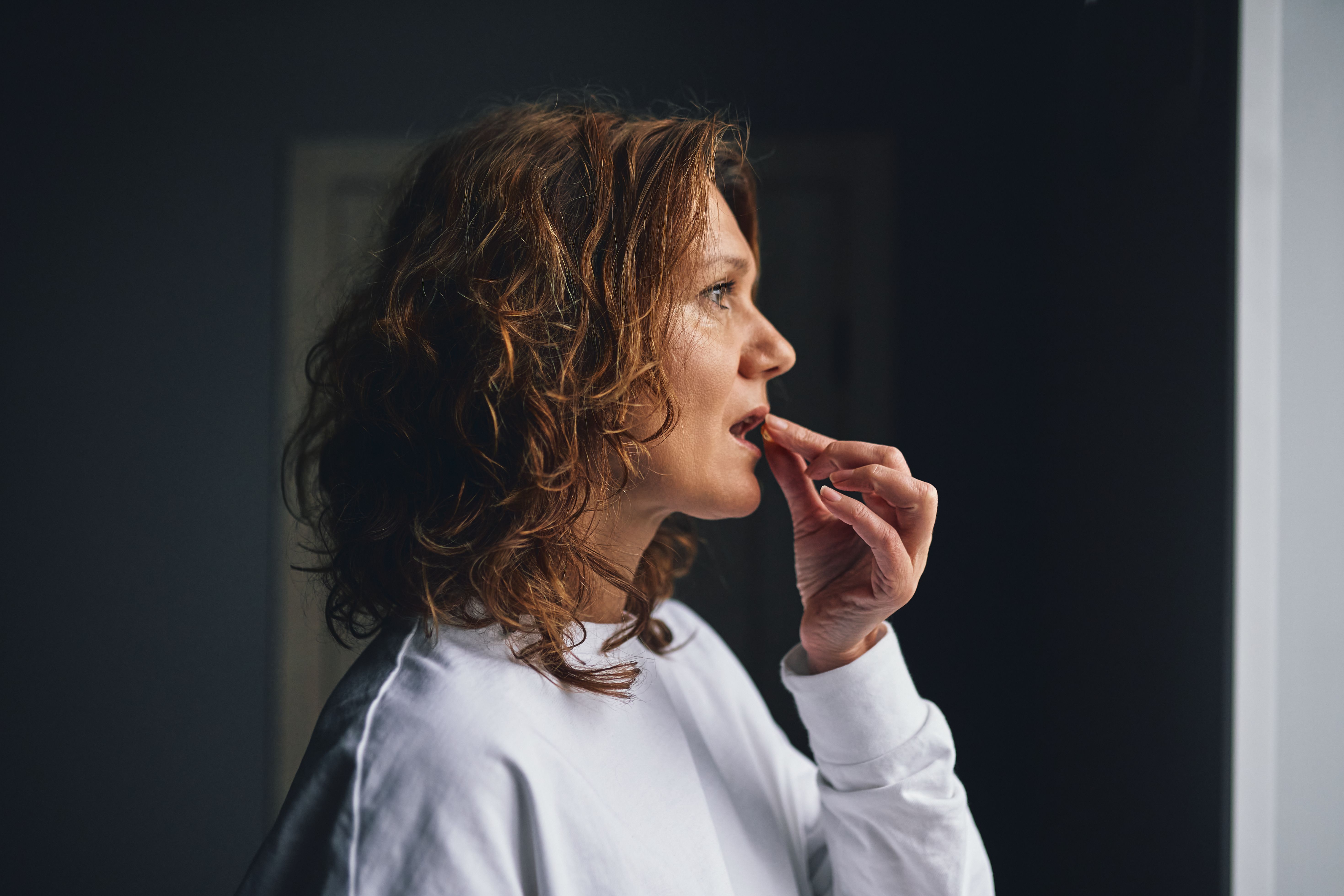 Frau nimmt eine Tablette und achtet auf ihre tägliche Gesundheit und Wellness.