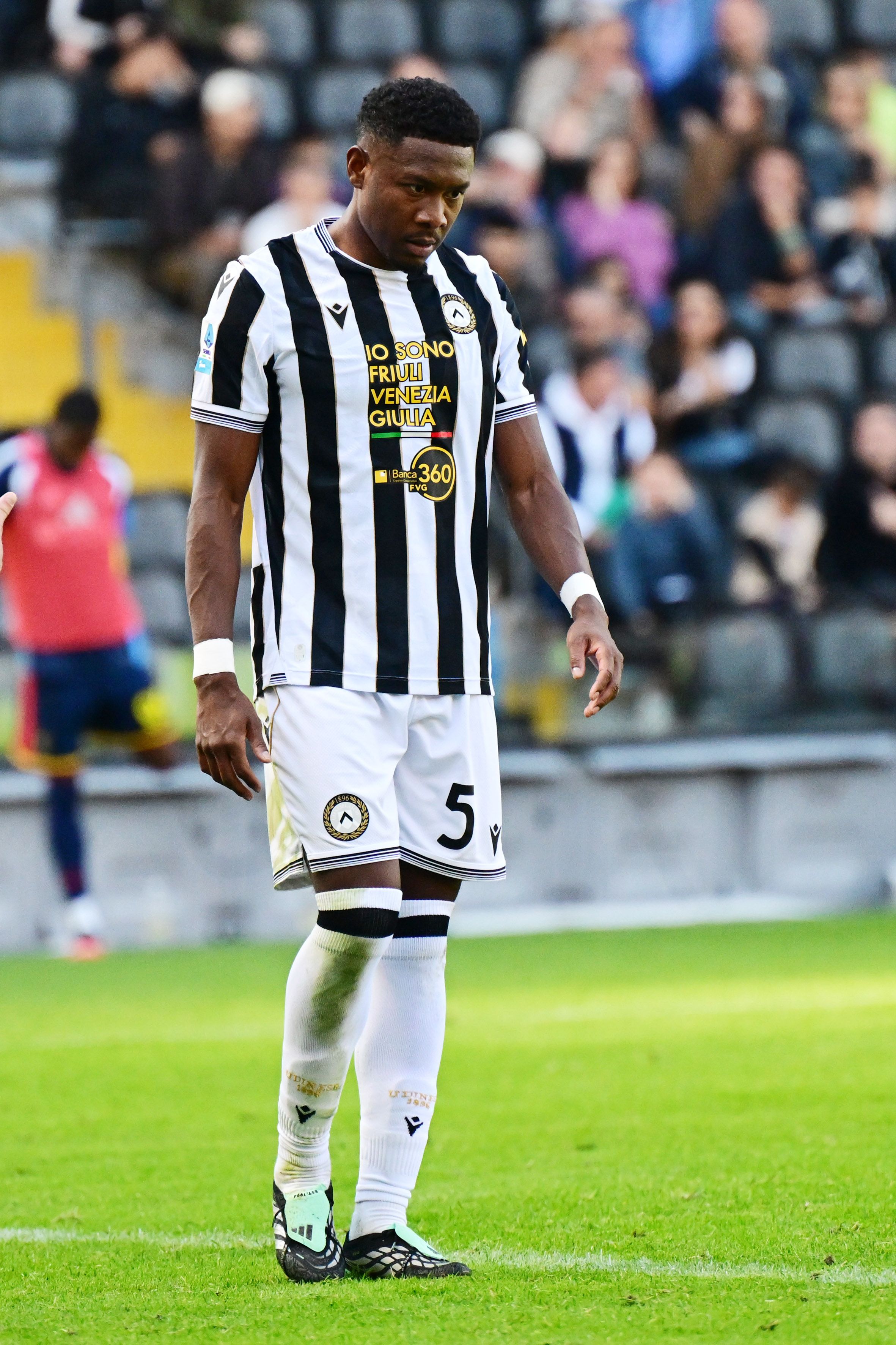 Ein Fußballspieler von Udinese Calcio steht nachdenklich auf dem Spielfeld.
