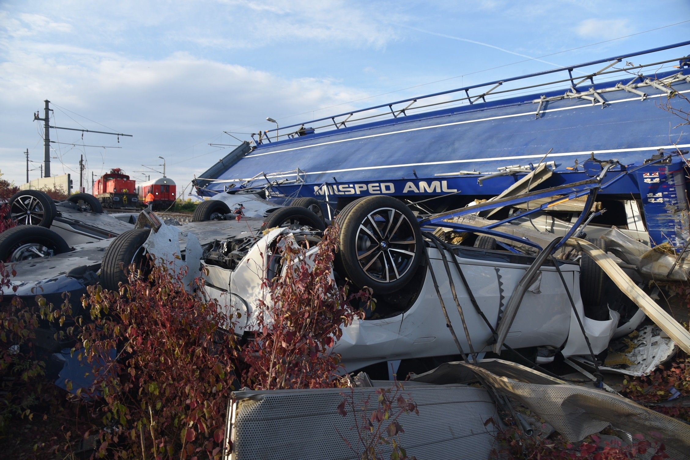 Mehrere zerstörte Autos und ein entgleister Güterzug liegen auf einem Bahndamm.