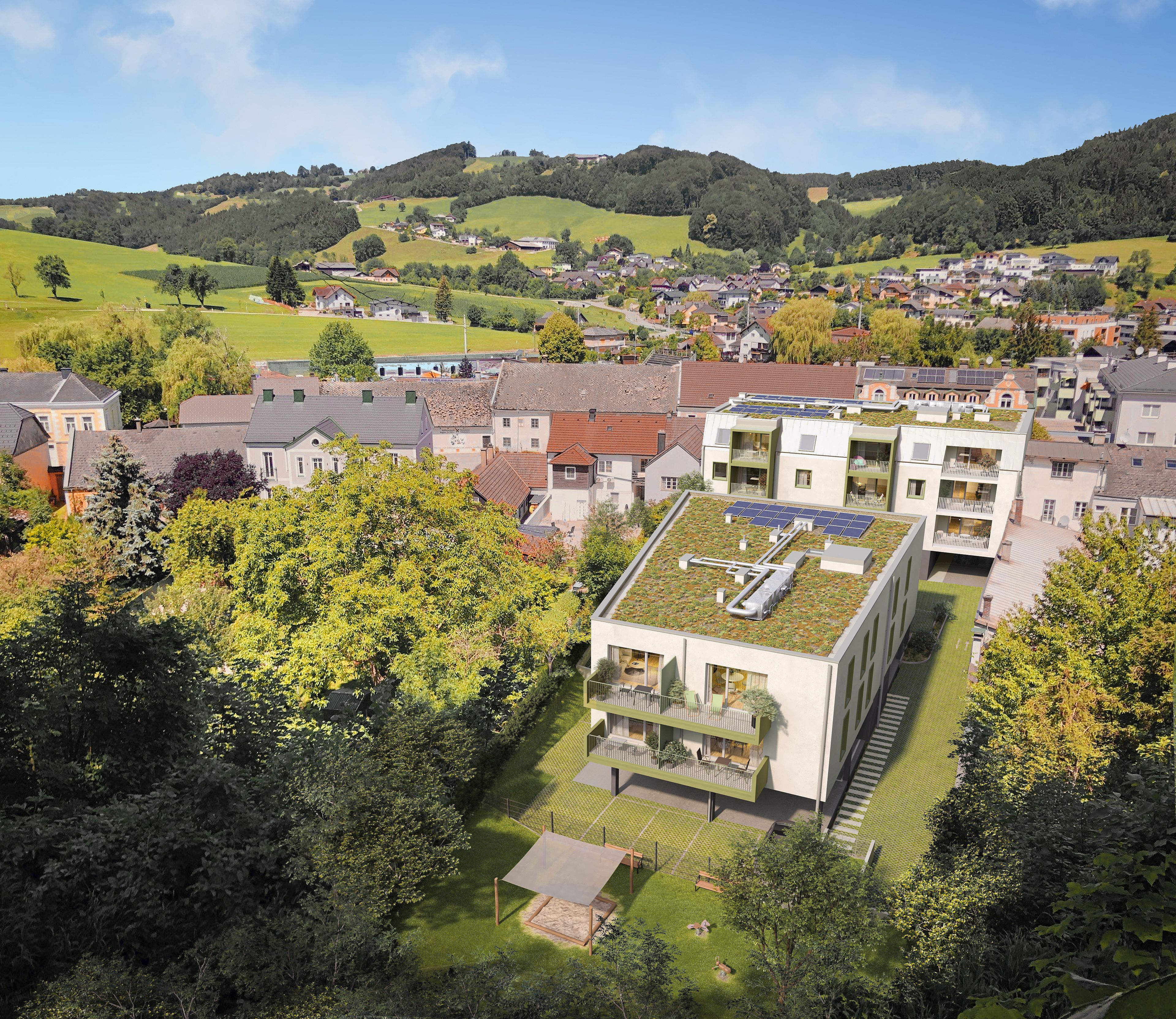Modernes Wohngebäude mit begrüntem Dach und Solarpanels inmitten eines grünen, ländlichen Dorfs.