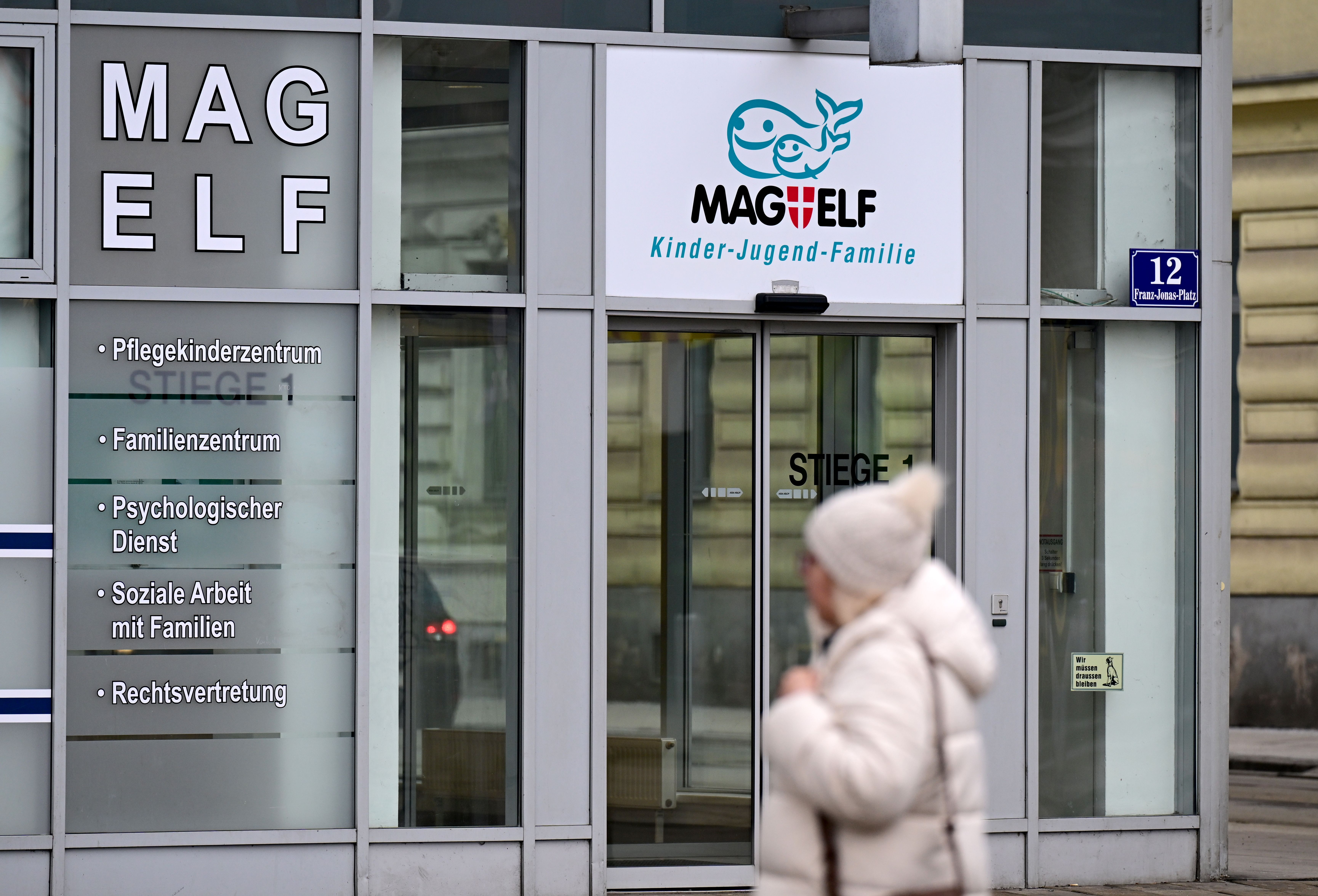 Eingang zur MAG ELF, Kinder- und Jugendhilfe Wien, mit vorbeigehender Person im Wintermantel.