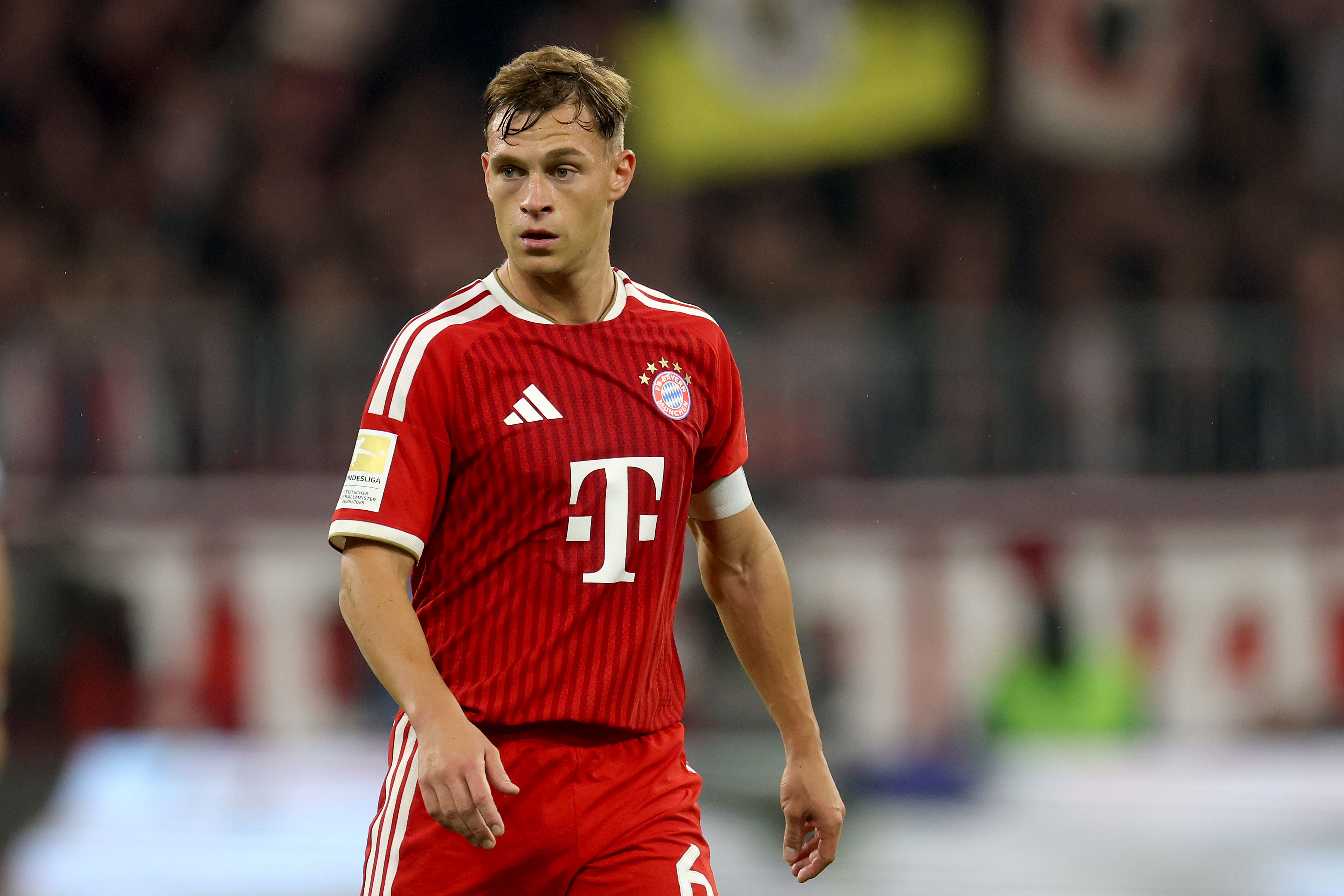 Ein Fußballspieler im roten FC Bayern München Trikot auf dem Spielfeld.