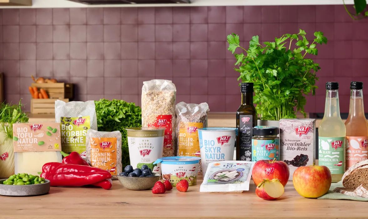 Verschiedene Bio-Lebensmittel und frisches Obst und Gemüse auf einer Küchenarbeitsplatte.