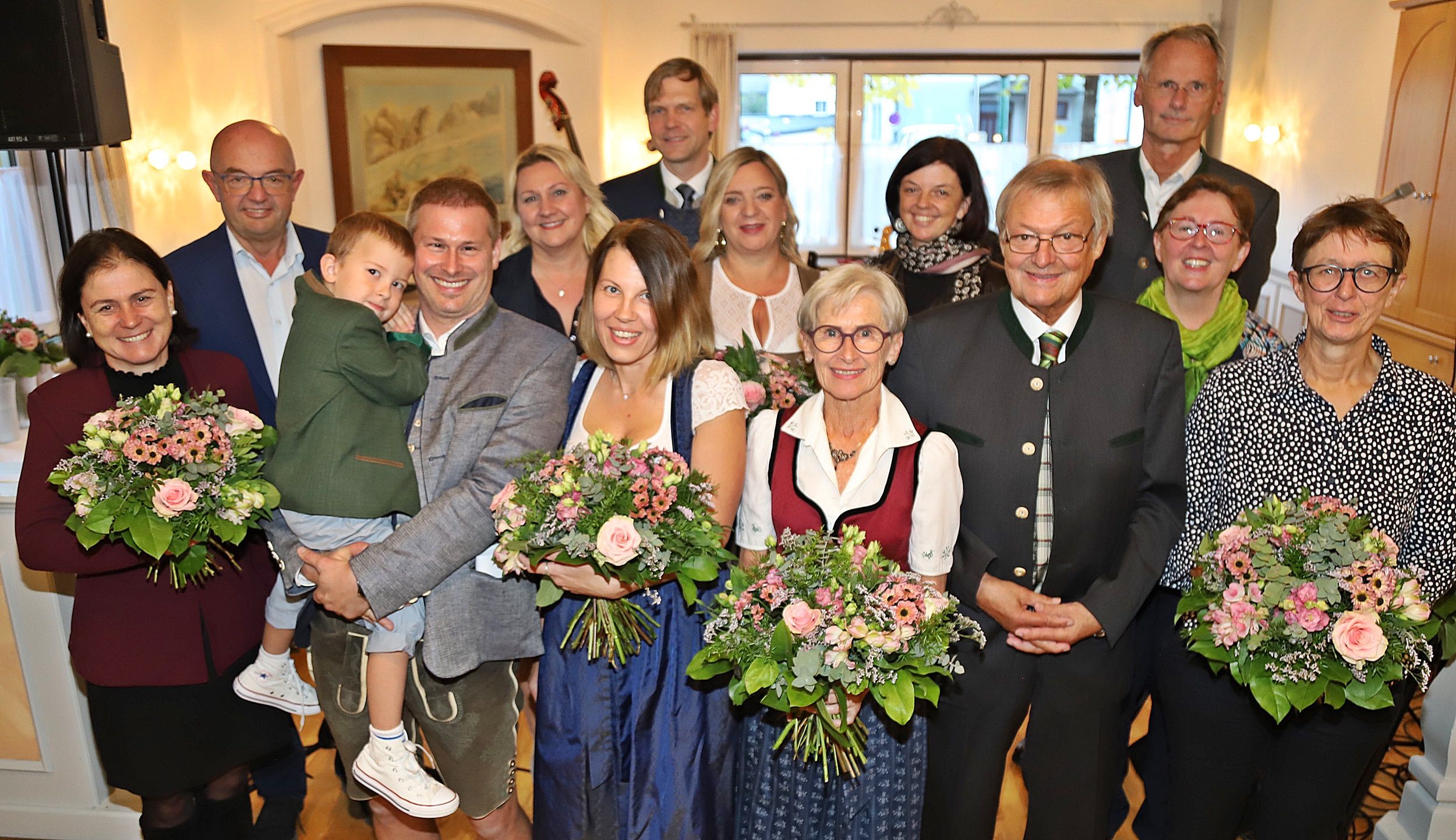 Gruppe von Menschen beim traditionellen Herbstfest der Traunseewirte, viele halten Blumensträuße.