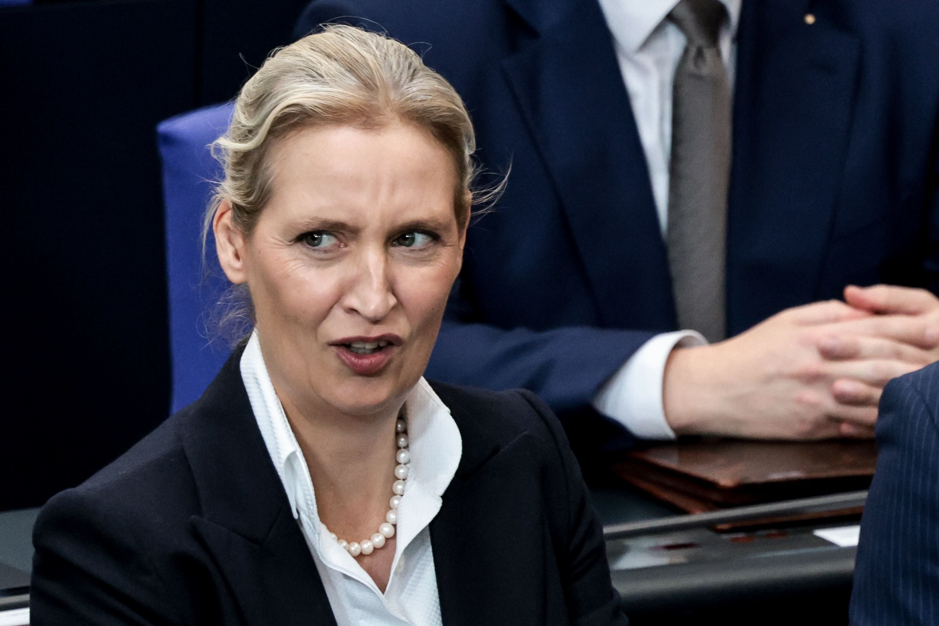 Eine Frau im Anzug und mit Perlenkette reagiert während einer Parlamentssitzung in Berlin.