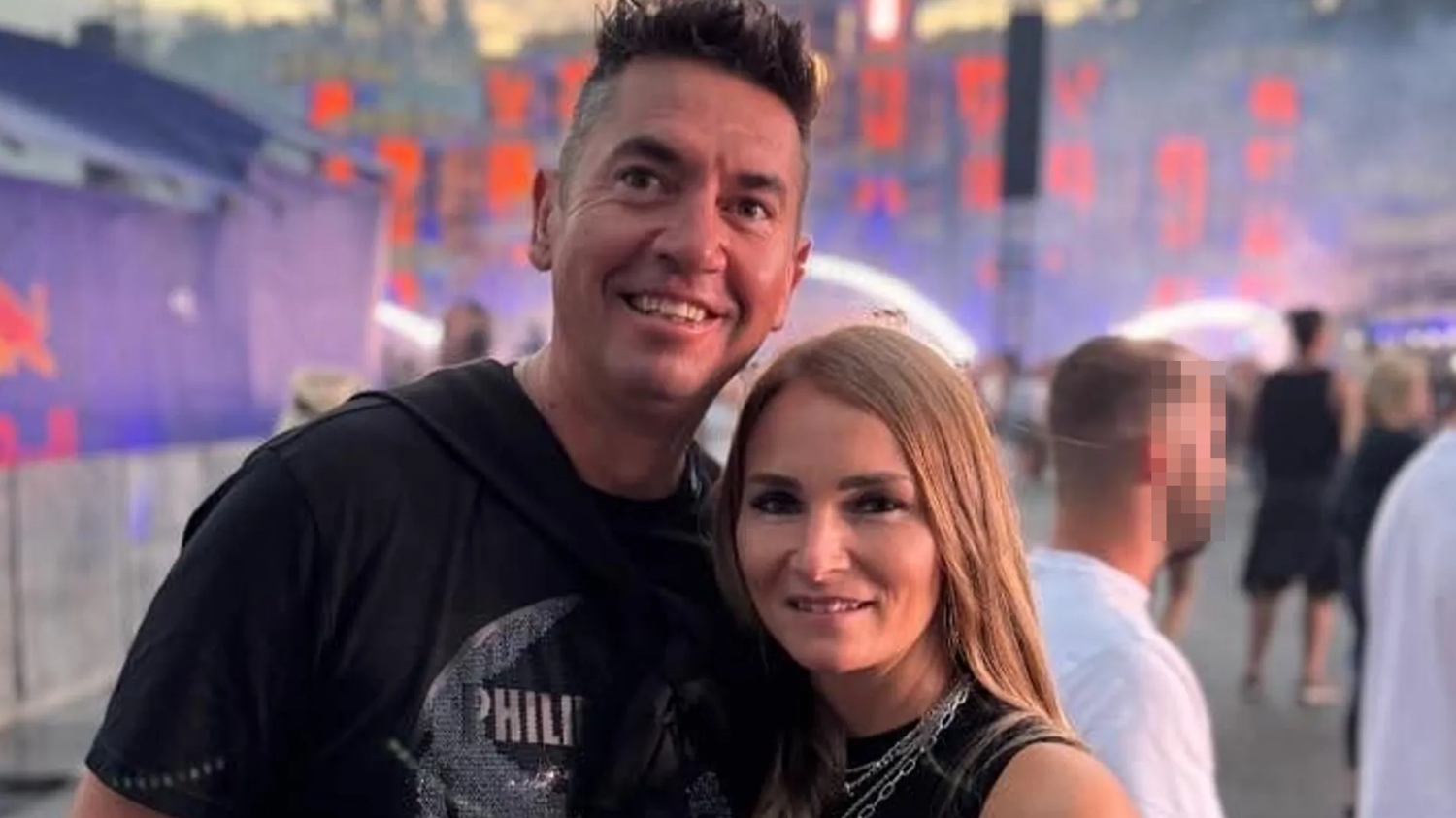 Ein Mann und eine Frau posieren lächelnd auf einem Musikfestival im Freien.