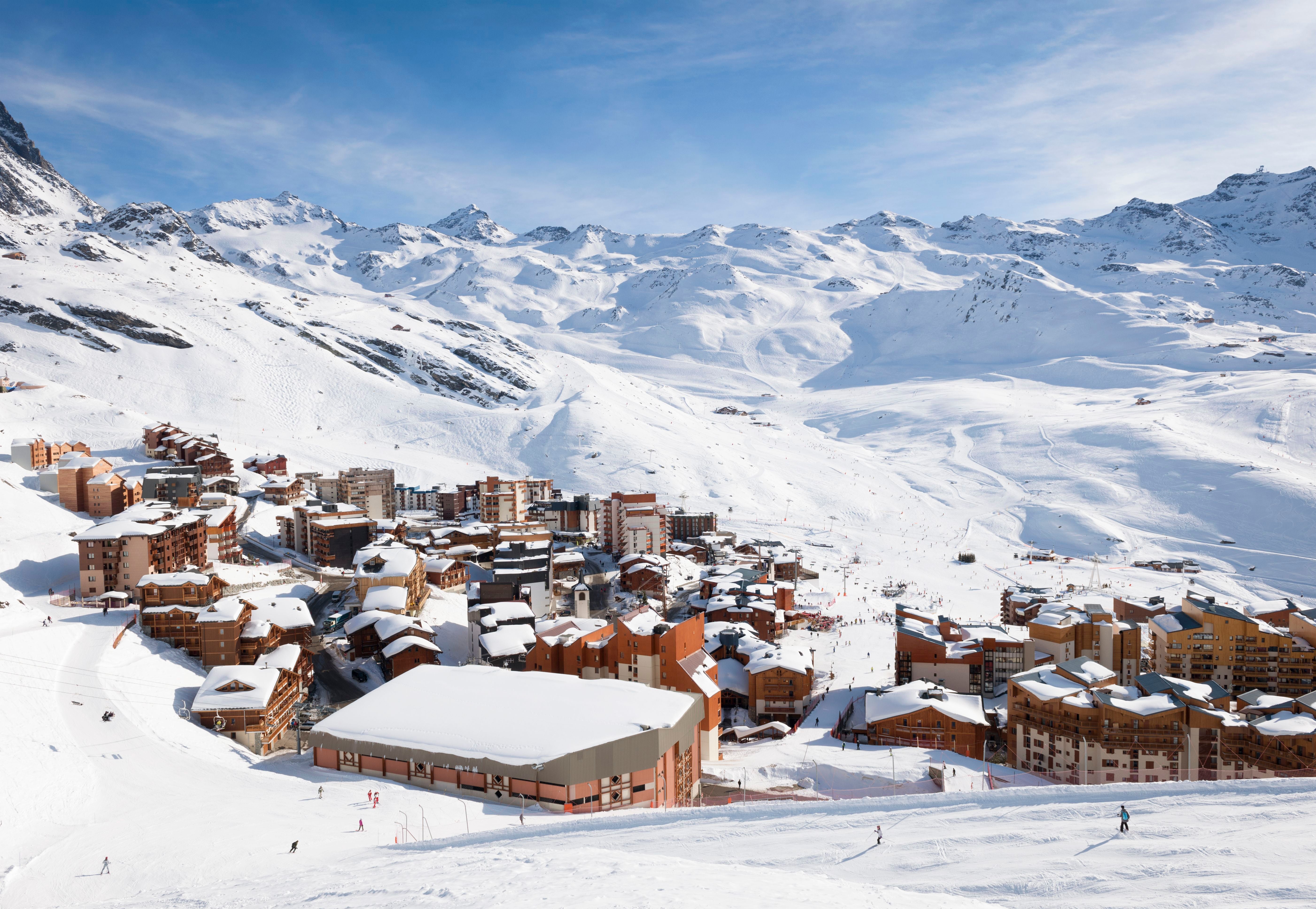 Schneebedeckter Skiort Val Thorens mit Skifahrern auf den umliegenden Pisten und Bergen.