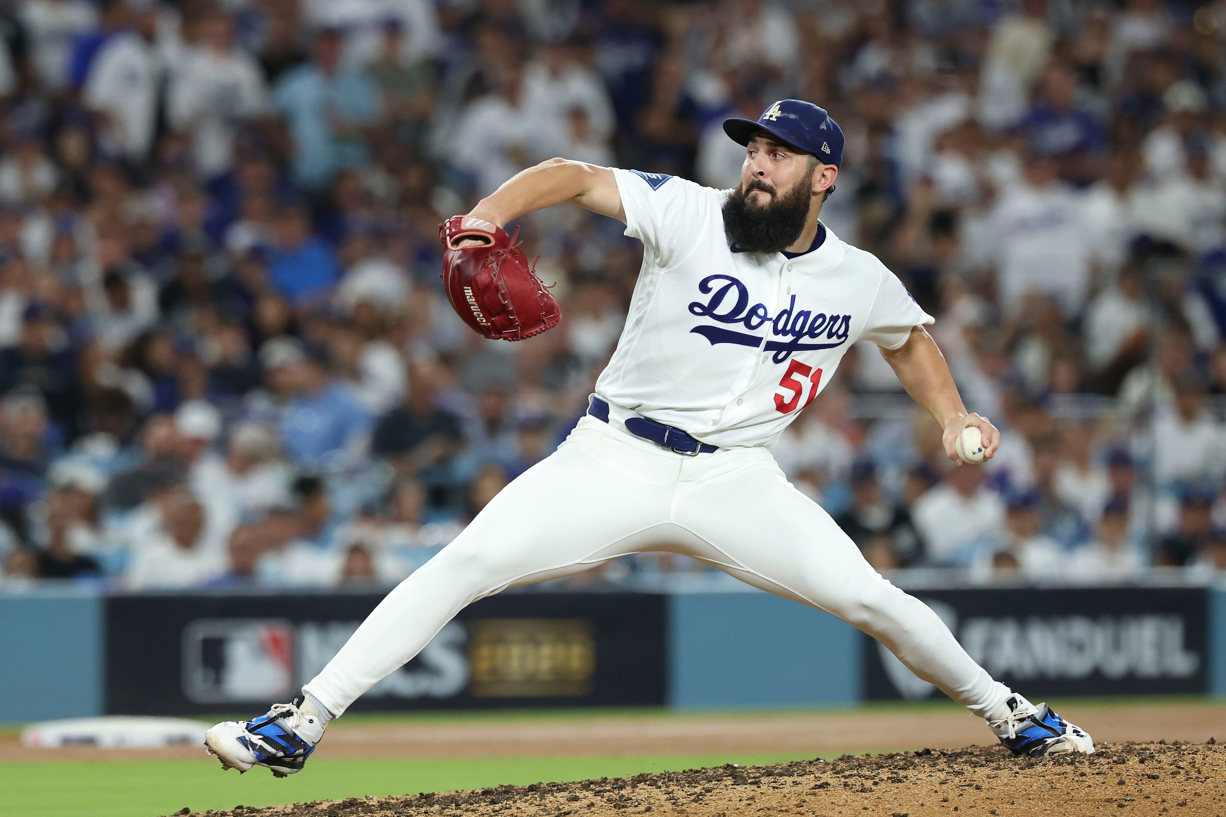 Baseball-Pitcher Alex Vesia im weißen Trikot der Los Angeles Dodgers mit der Rückennummer 51 holt auf dem Wurfhügel mit rotem Handschuh zum Wurf aus.