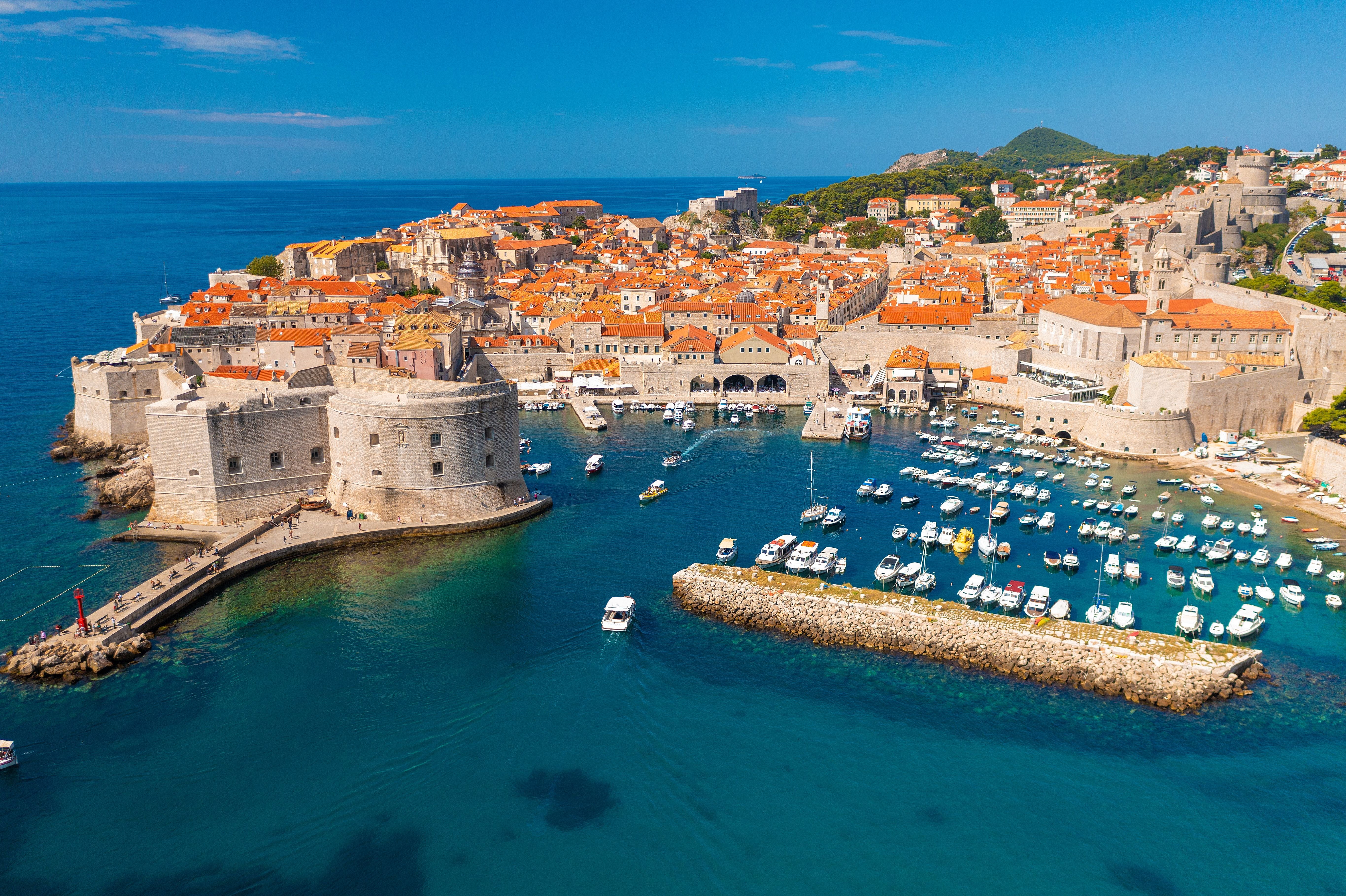 Luftaufnahme der Altstadt von Dubrovnik mit Hafen und vielen kleinen Booten.