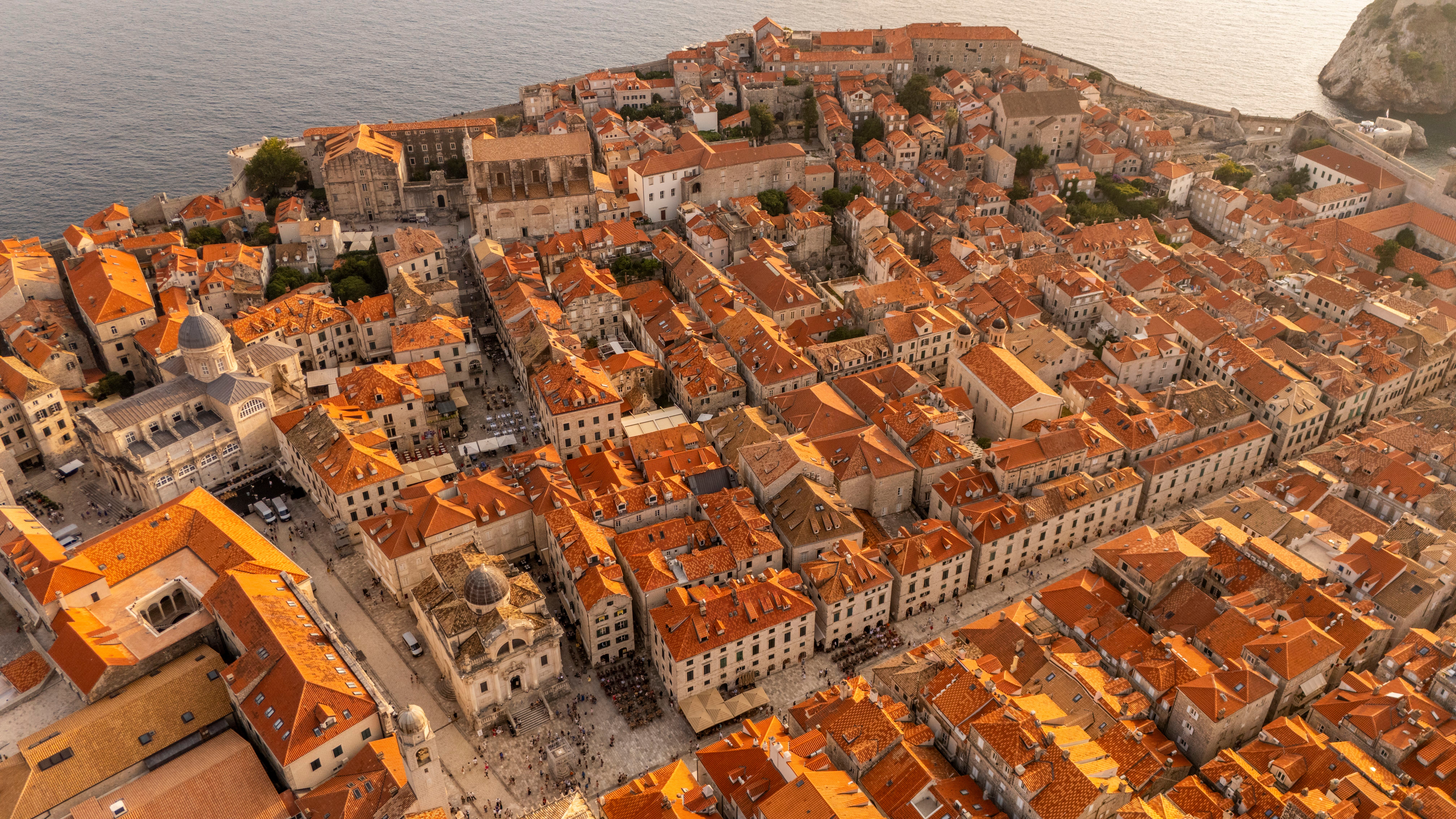 Luftaufnahme der Altstadt von Dubrovnik mit roten Dächern und Steinmauern am Adriatischen Meer.