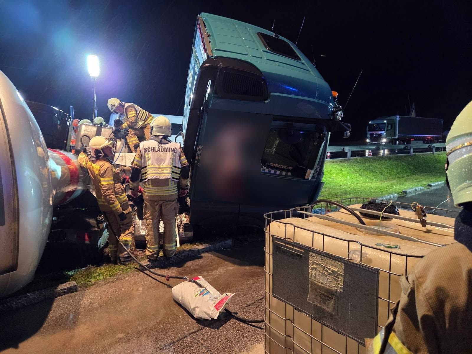 Feuerwehrleute bergen einen umgestürzten LKW bei einem nächtlichen Unfall nahe Schladming.