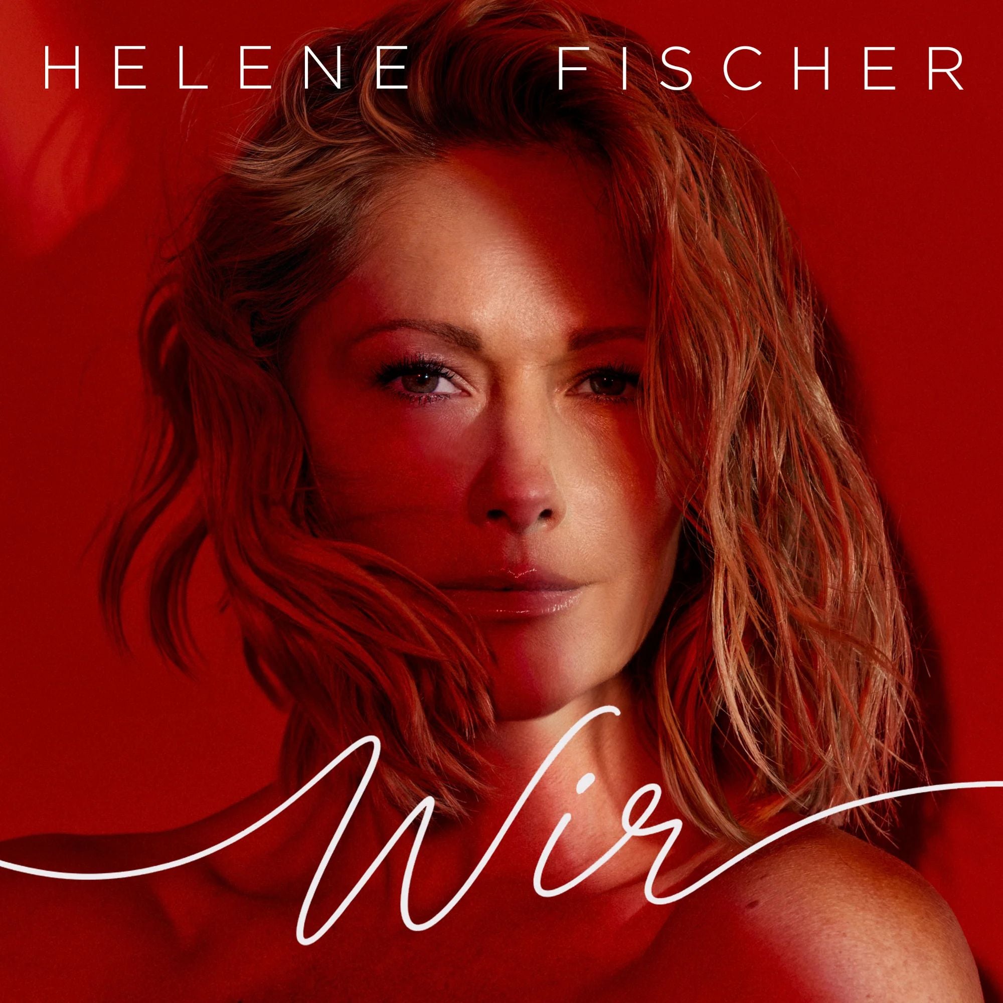 Porträt einer Frau mit roten Haaren vor rotem Hintergrund, Schriftzug „Helene Fischer Wir“.