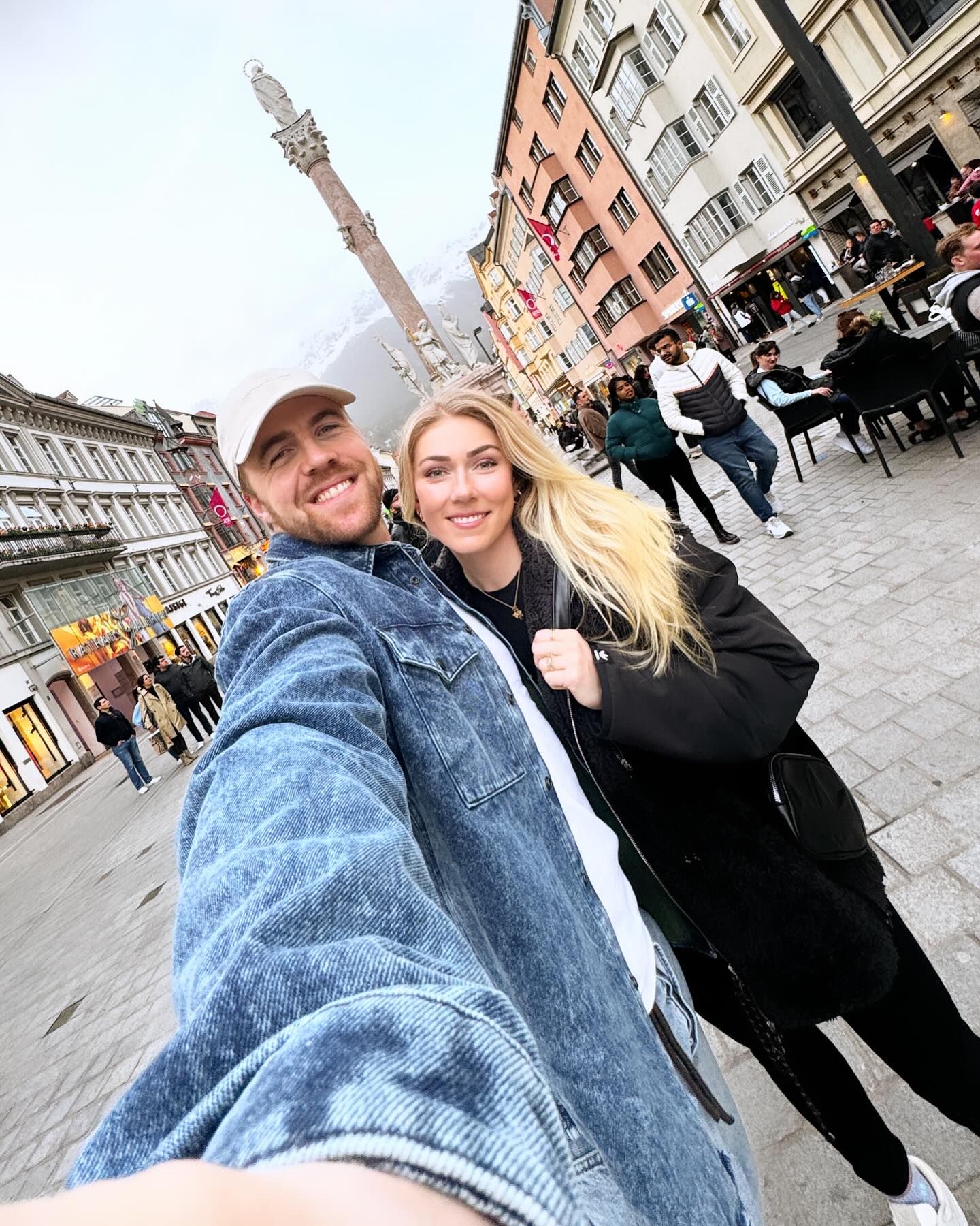 Aleksander Aamodt Kilde und seine Verlobte Mikaela Shiffrin lächeln gemeinsam bei einem Selfie in einer Fußgängerzone.