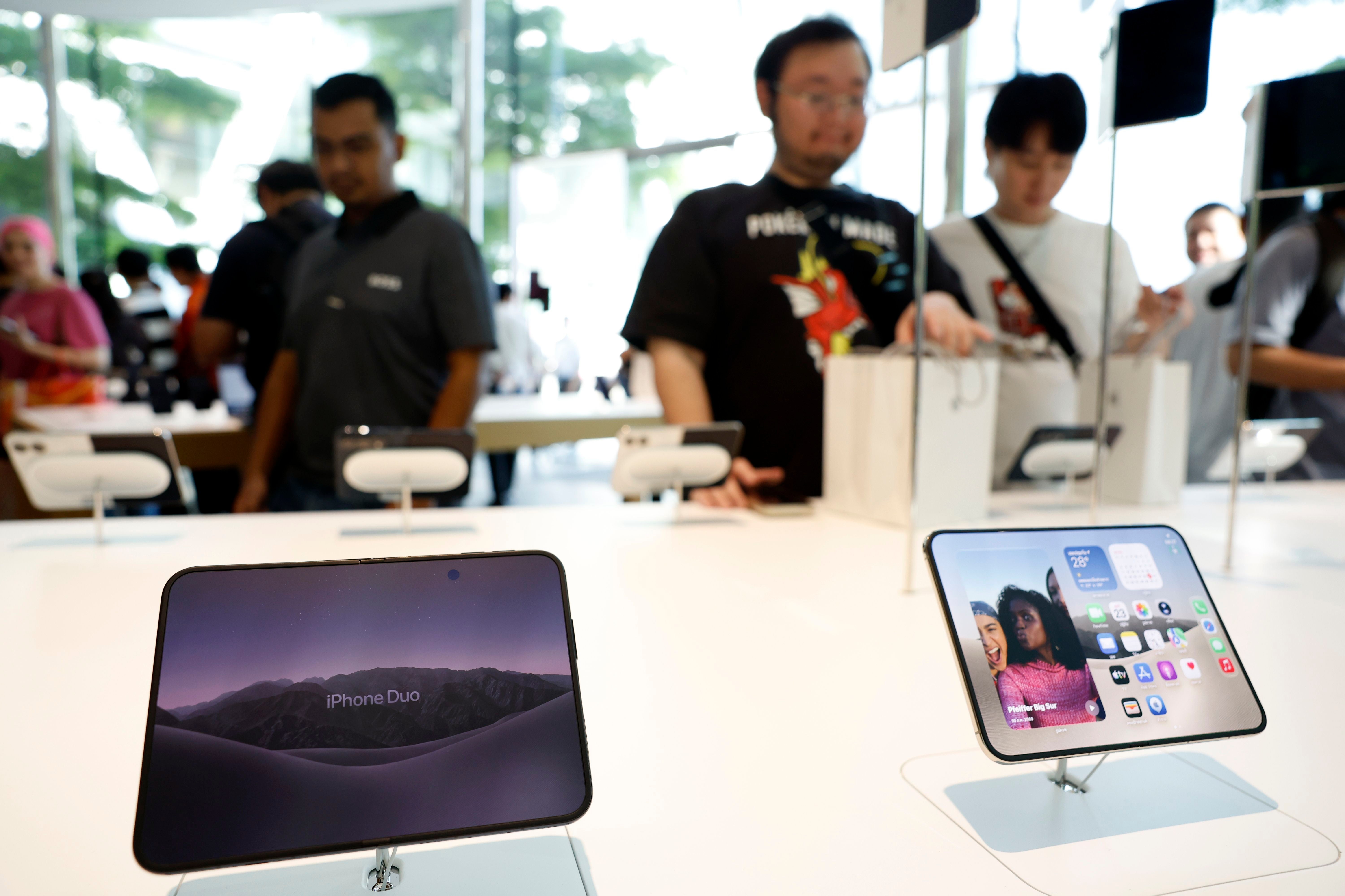 Kunden betrachten das neue faltbare iPhone Duo in einem Apple Store in Bangkok.