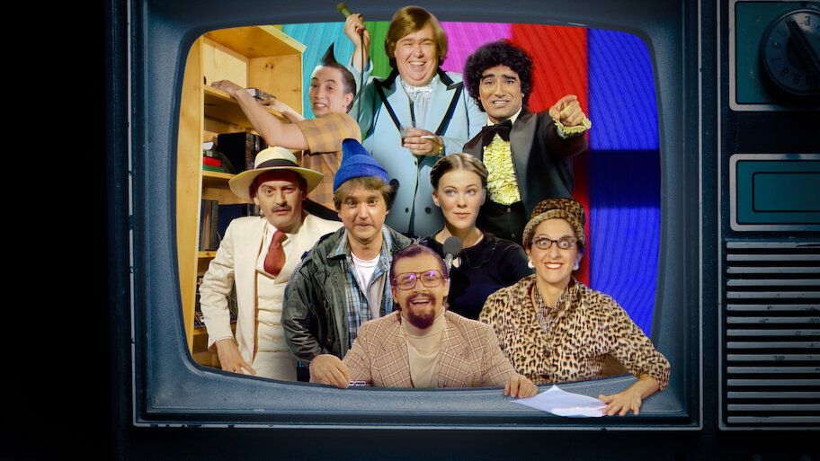 Mehrere verkleidete Menschen posieren fröhlich in einem alten Fernsehgerät.