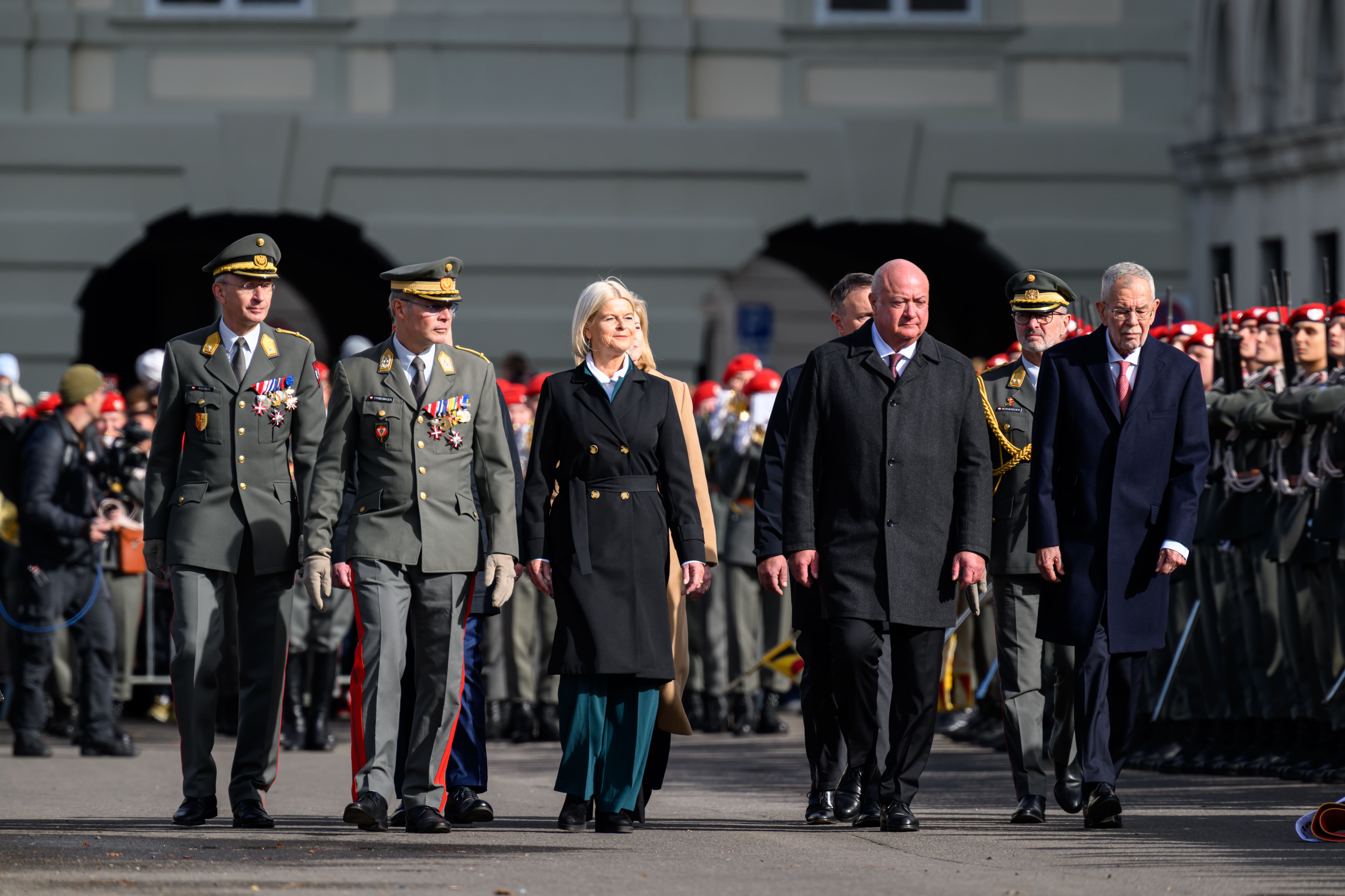 Gruppe von Politiker:innen und Militärs gehen am Nationalfeiertag am Heldenplatz in Wien.