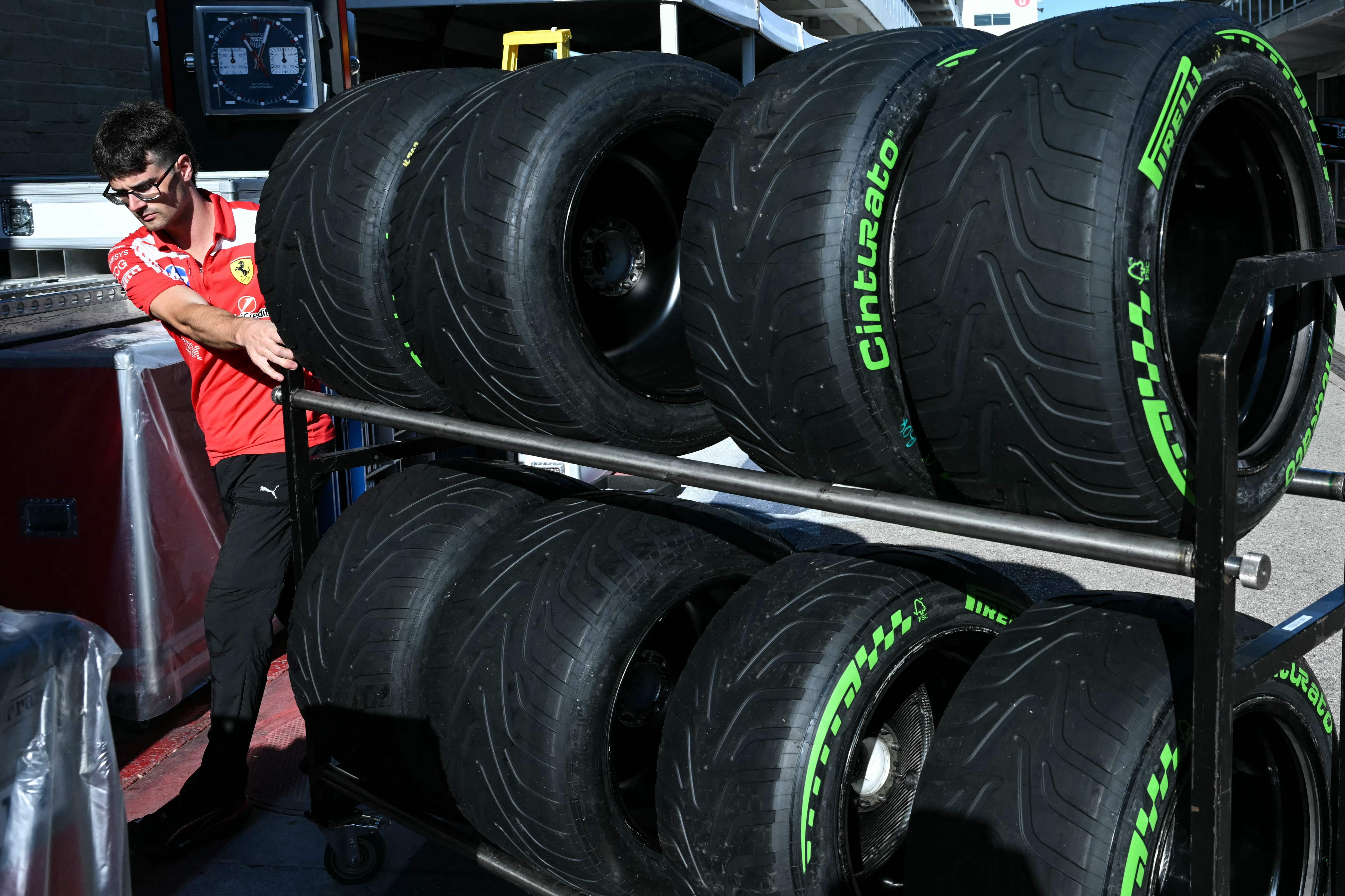 A Ferrari crew member moves tires near the garages ahead of the United States Formula One Grand Prix at the Circuit of the Americas in Austin, Texas, on October 22, 2026. The United States Grand Prix will take place on Sunday, October 25. (Photo by RONALDO SCHEMIDT / AFP)