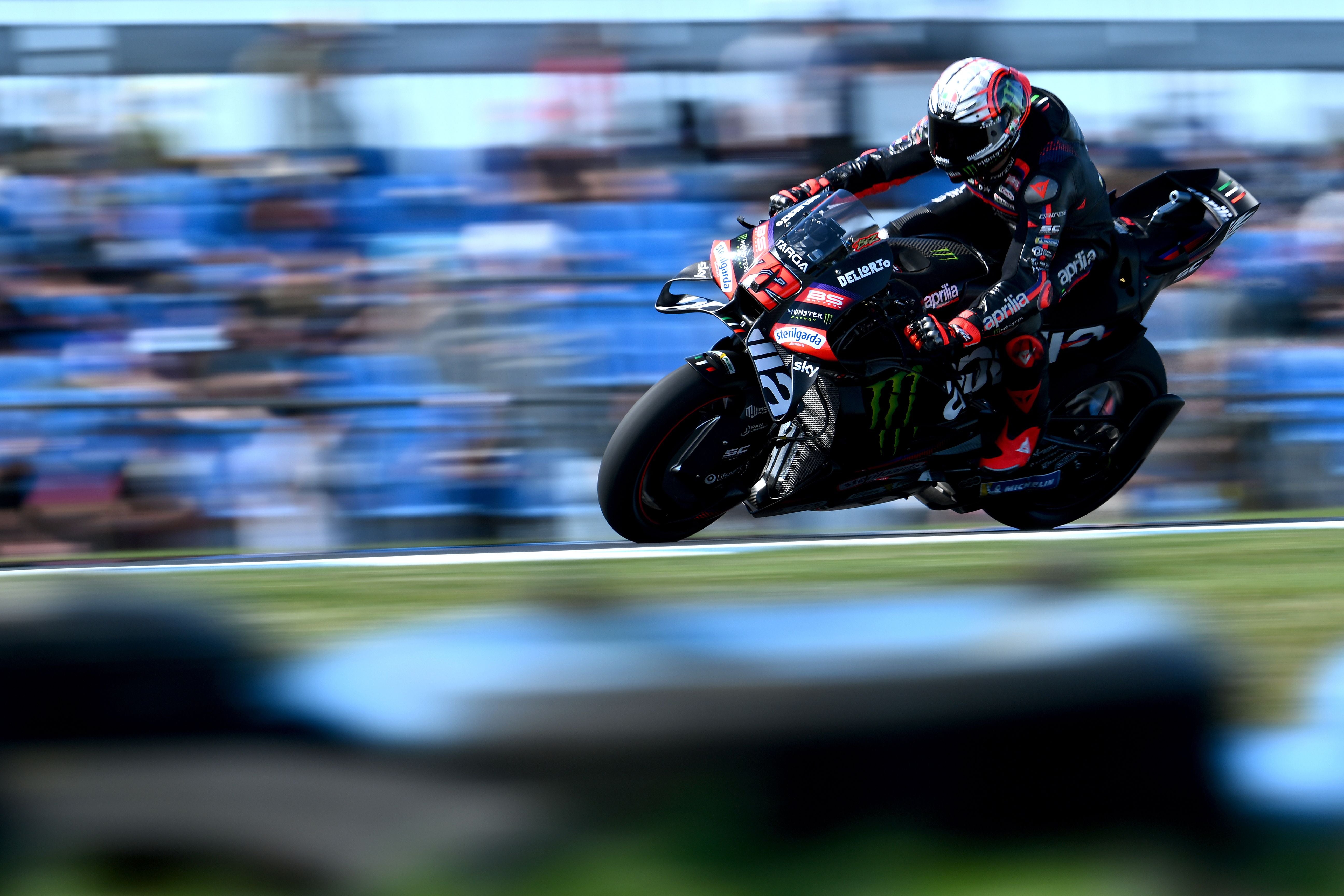 MotoGP-Fahrer Marco Bezzecchi lehnt sich in hoher Geschwindigkeit auf seiner schwarzen Aprilia in eine Kurve auf dem Circuit von Phillip Island.
