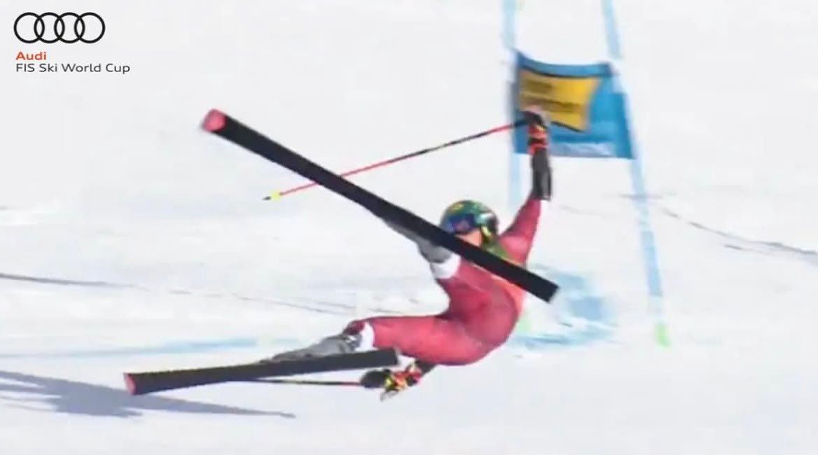 Ein Skifahrer stürzt beim FIS Ski World Cup vor einem blauen Tor auf der Piste.