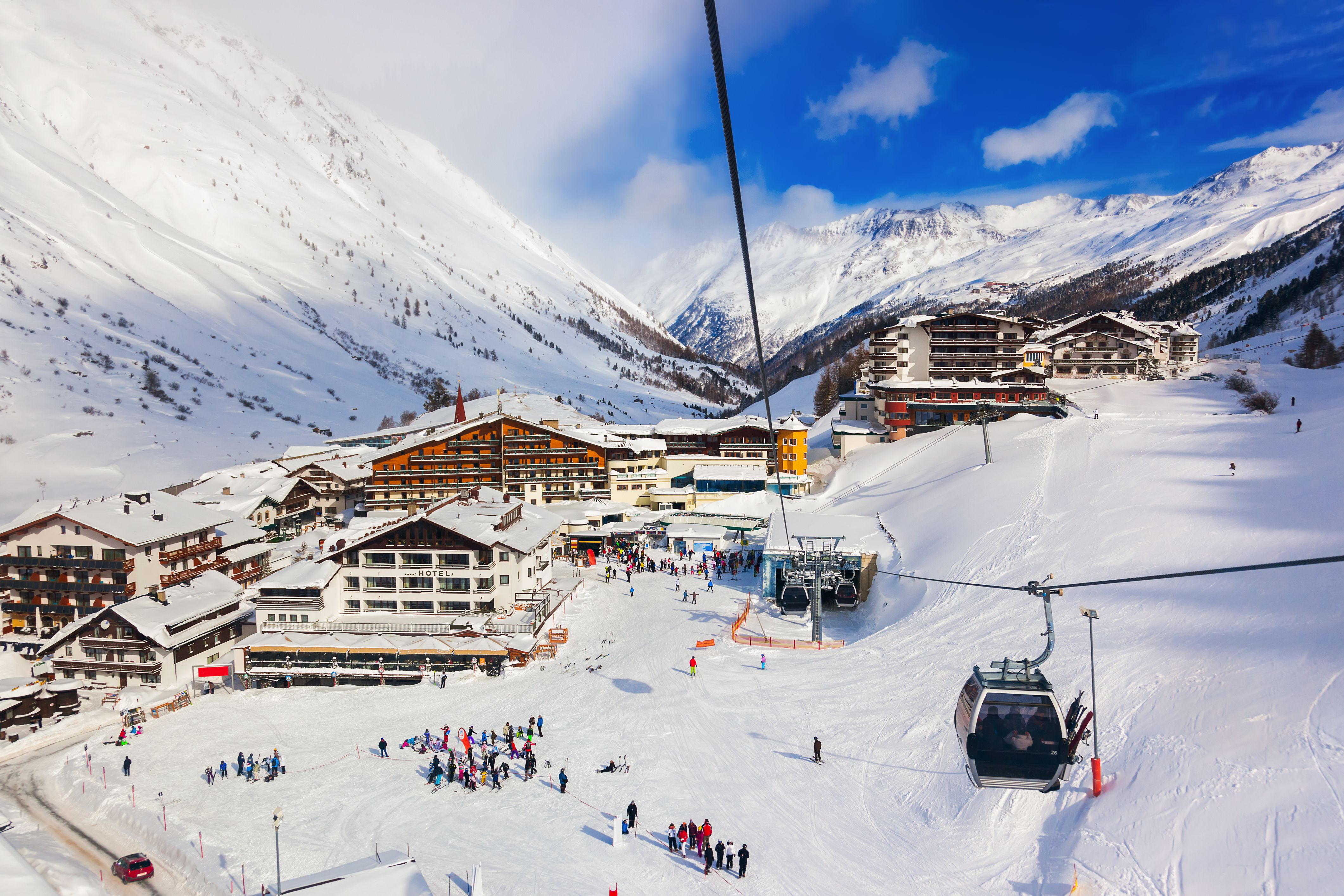 Verschneites Skigebiet mit Hotels, Skifahrern und Gondelbahn in den Alpen bei Obergurgl, Österreich.