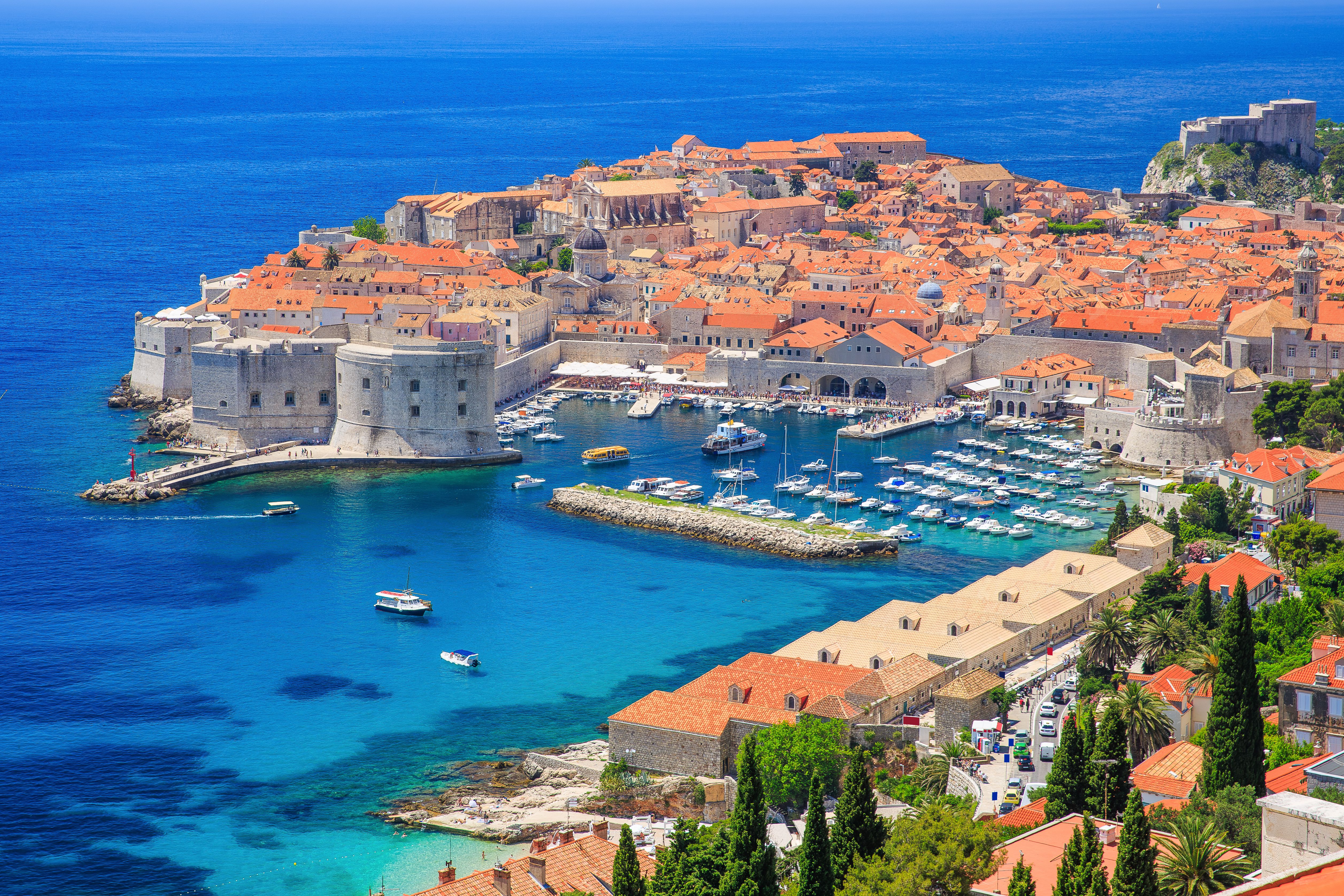 Panoramablick auf Dubrovniks Altstadt mit Stadtmauer und Hafen am blauen Meer.