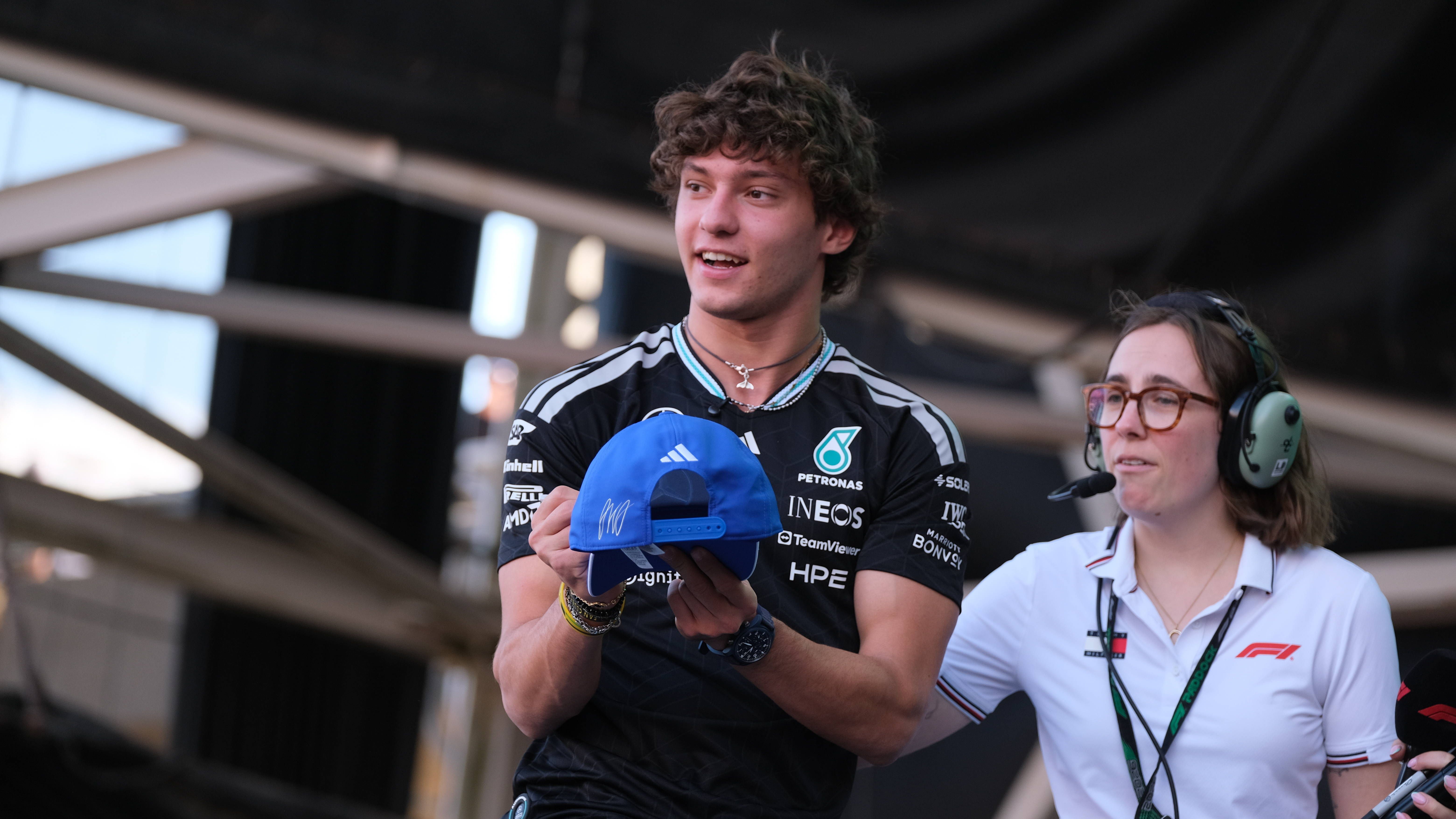 Junger Mann im Mercedes-Shirt hält eine blaue Kappe bei einer Formel-1-Veranstaltung in Austin.