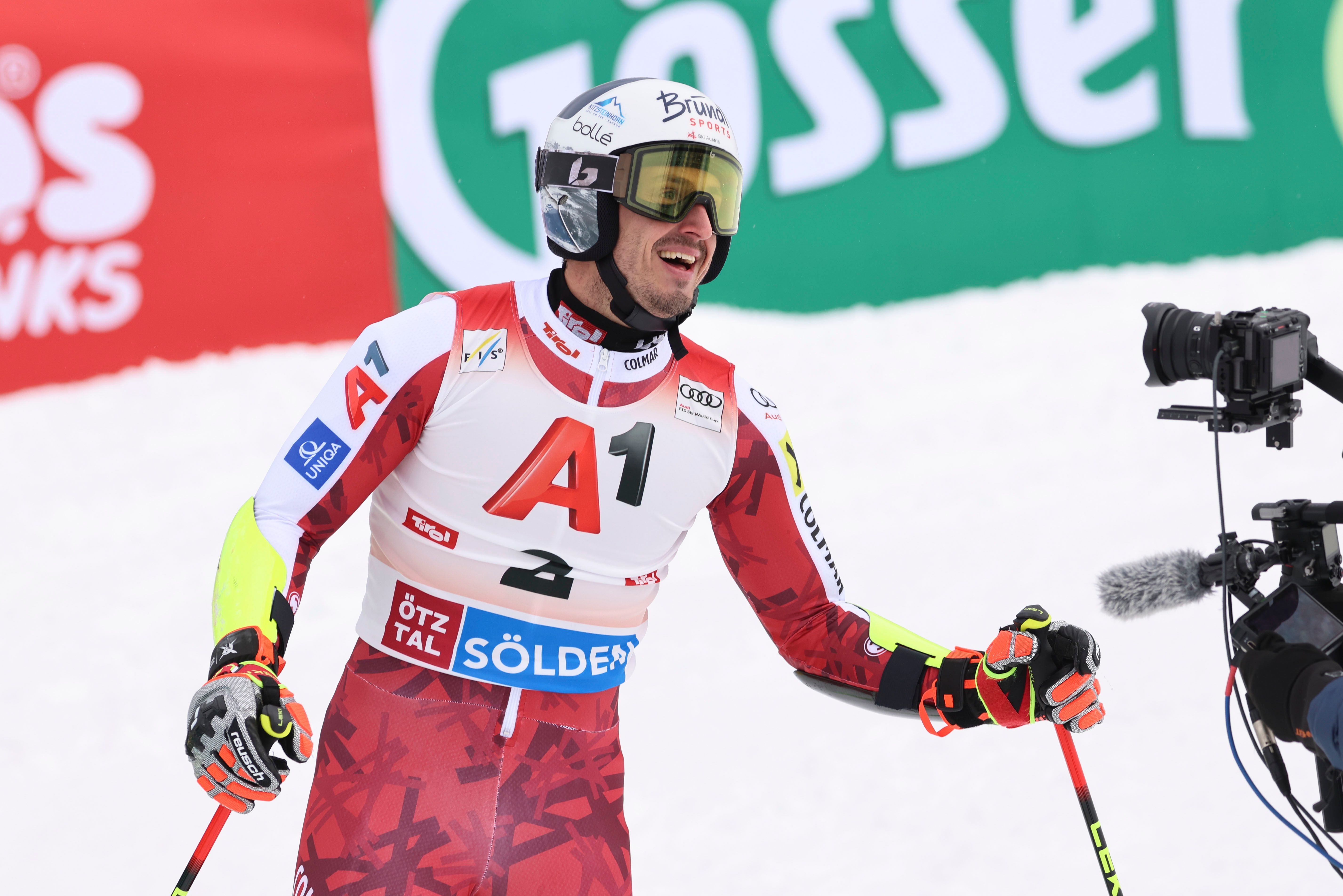 Ein Skirennläufer im Rennanzug freut sich im Ziel während eines Weltcup-Riesenslaloms.
