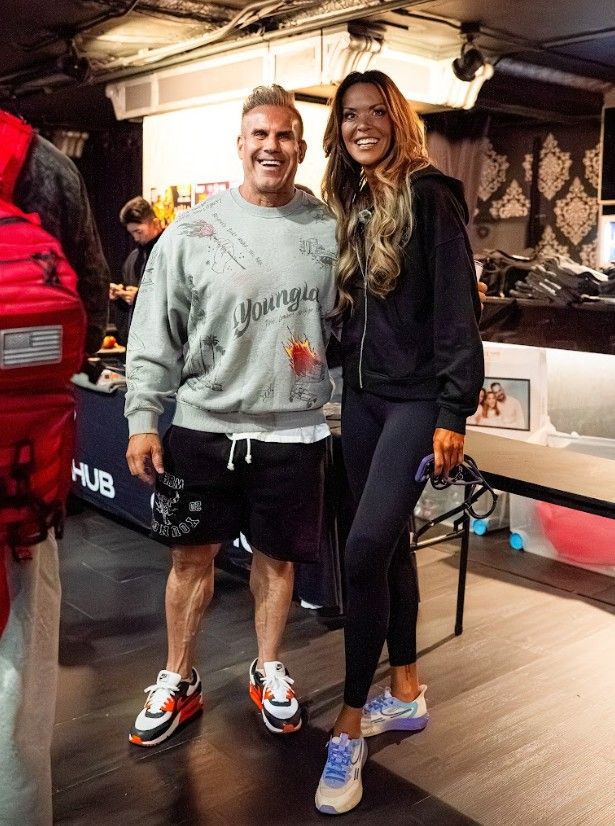 Ein Mann und eine Frau posieren gemeinsam in sportlicher Kleidung in einem Innenraum.