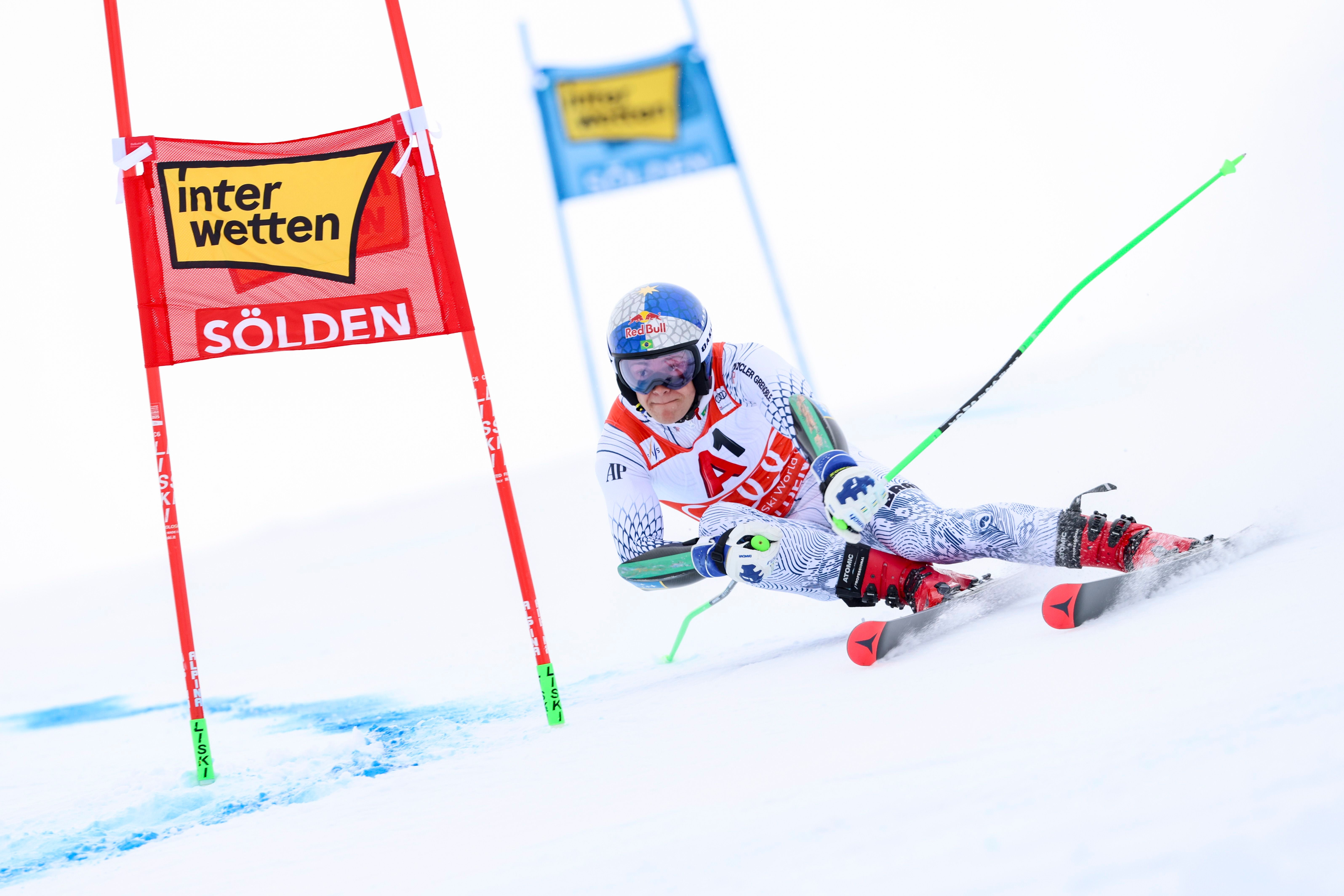 Ein Skirennläufer fährt beim Riesenslalom durch ein Tor auf schneebedeckter Piste in Sölden.