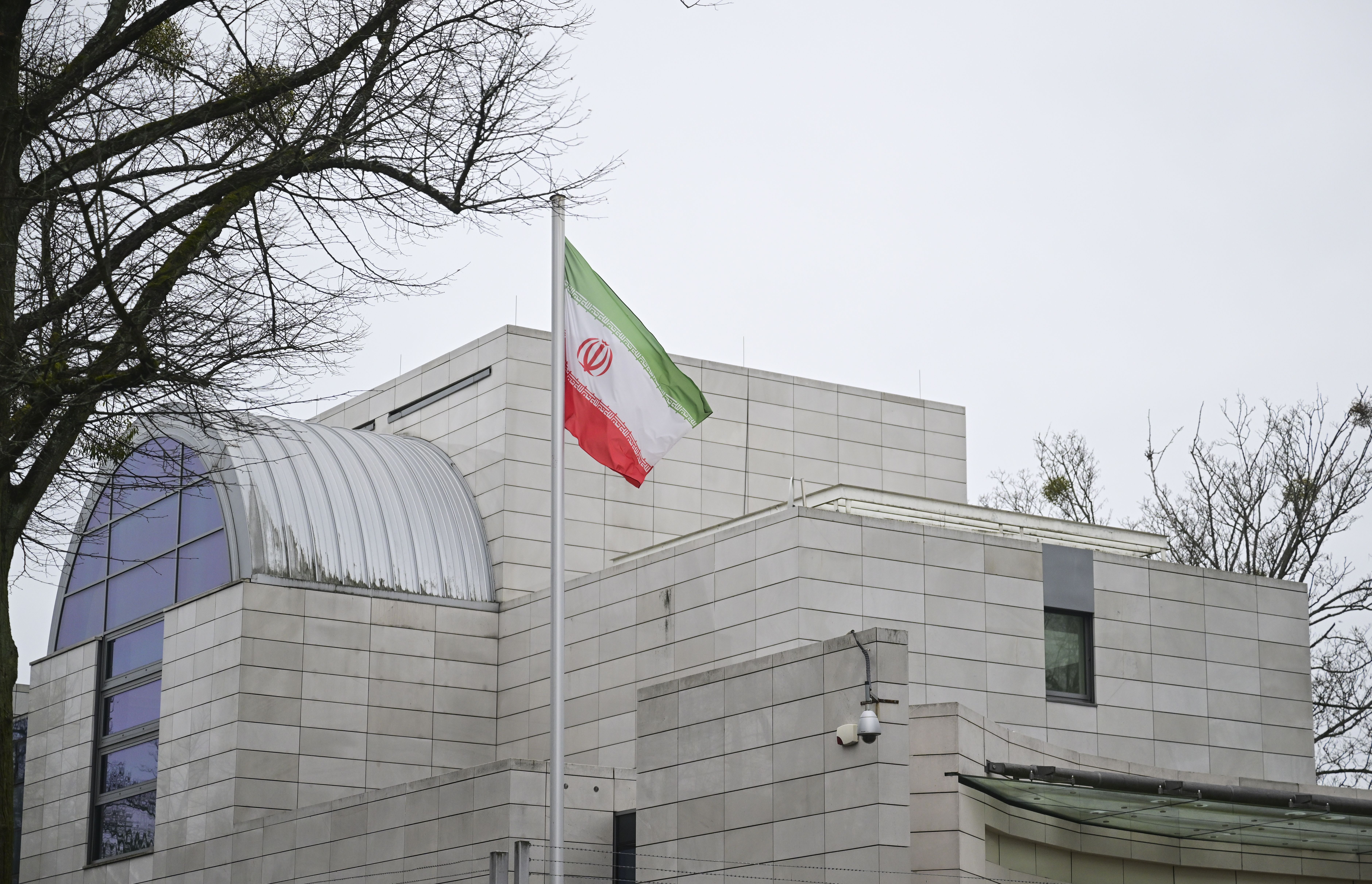 Die iranische Flagge weht vor der iranischen Botschaft in Berlin an einem bewölkten Tag.