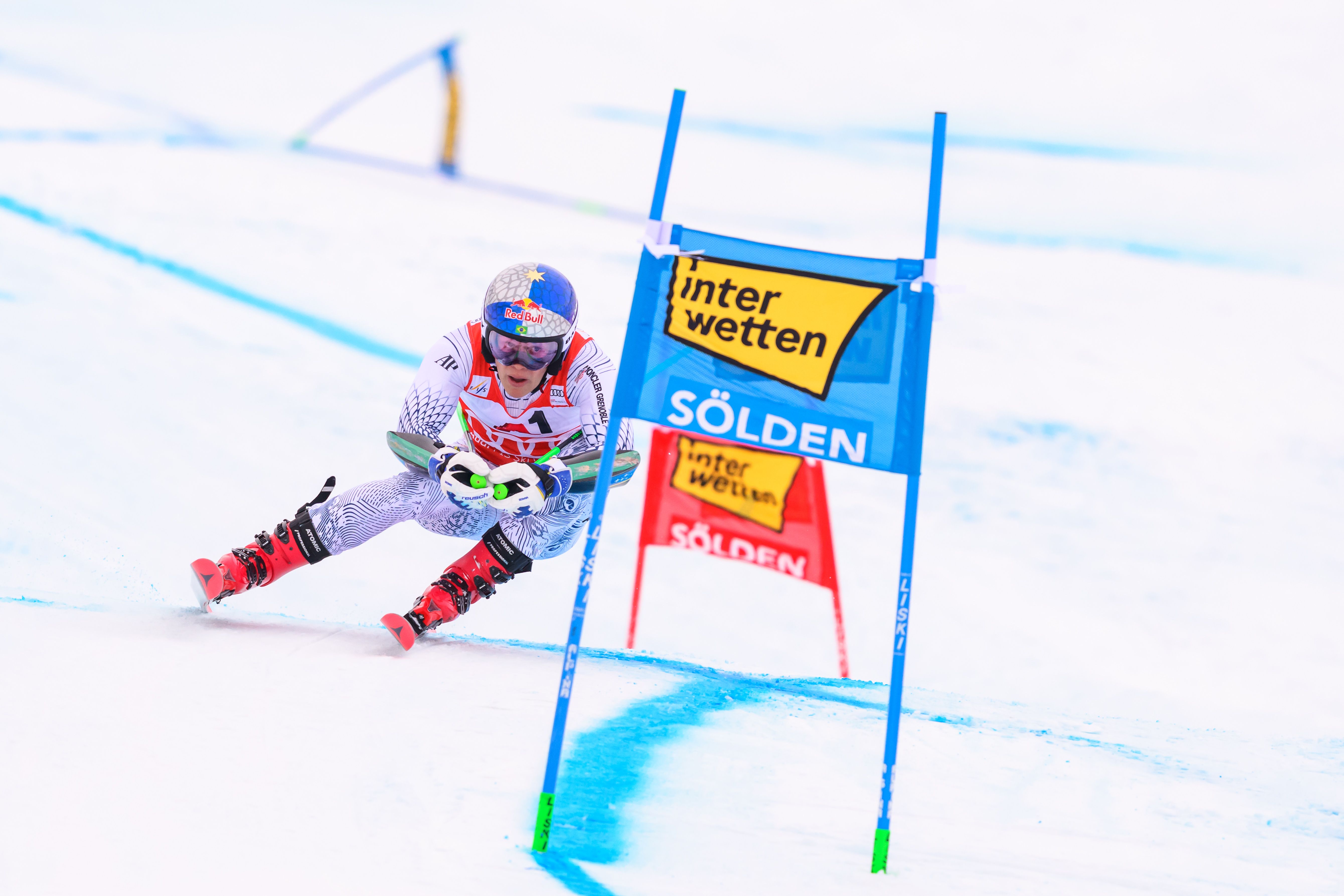 Ein Skifahrer fährt beim Riesenslalom am Tor in Sölden auf einer verschneiten Piste vorbei.