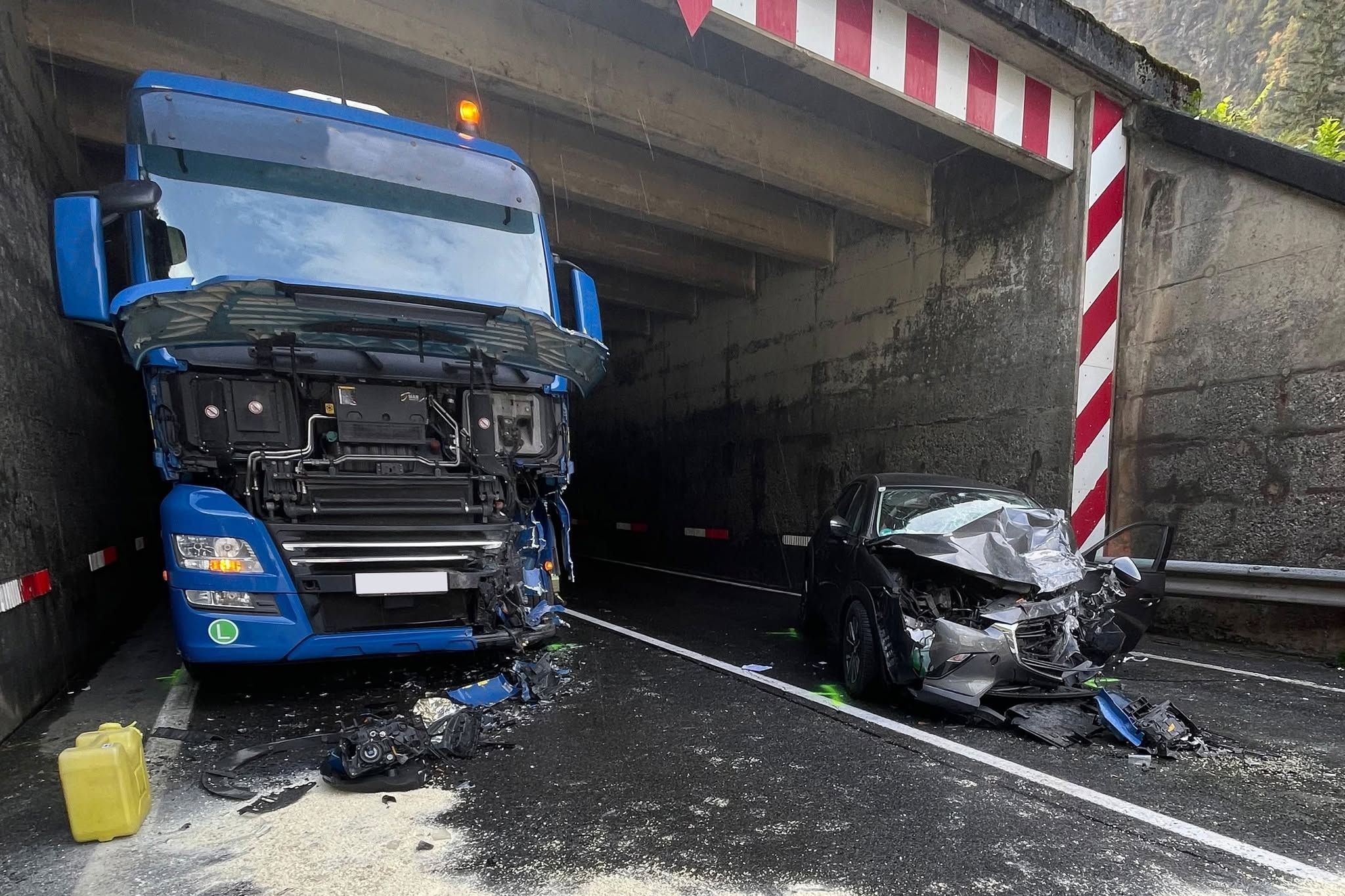 Schwerer Unfall mit Lkw und Auto in einem Tunnel, beide Fahrzeuge stark beschädigt.