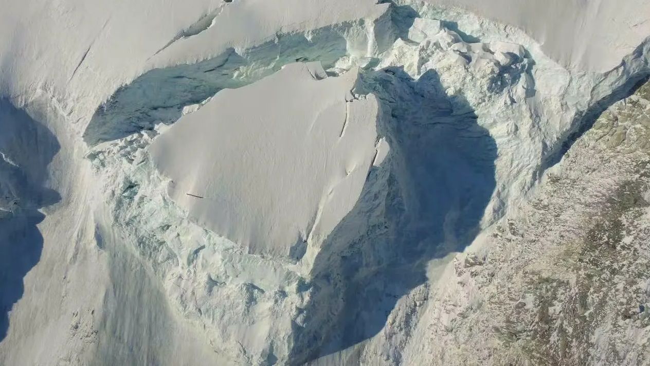 Luftaufnahme einer großen Eisspalte an einem verschneiten Berghang bei Randa.