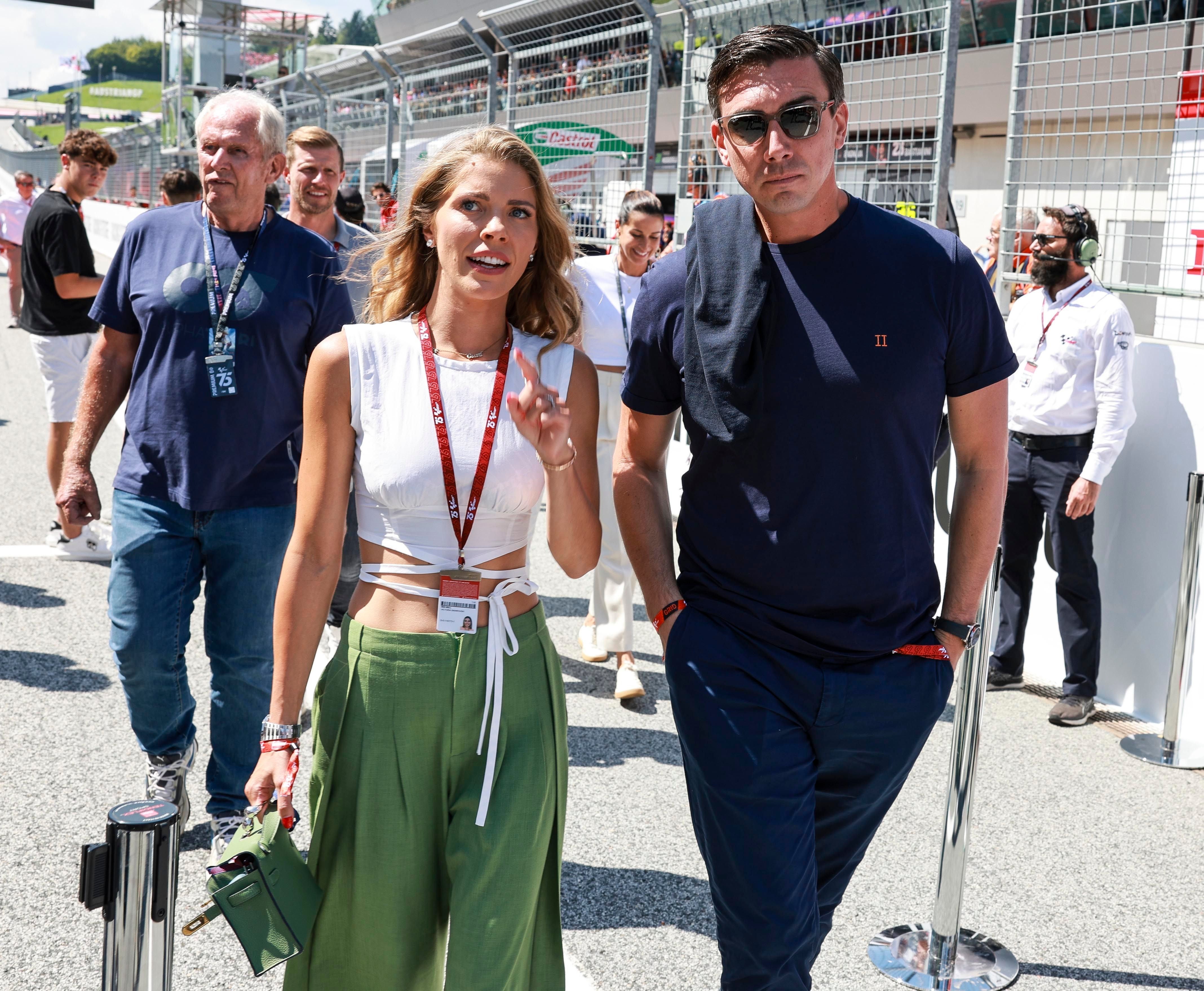 Mehrere Menschen gehen entlang der Rennstrecke am Red Bull Ring bei sonnigem Wetter.